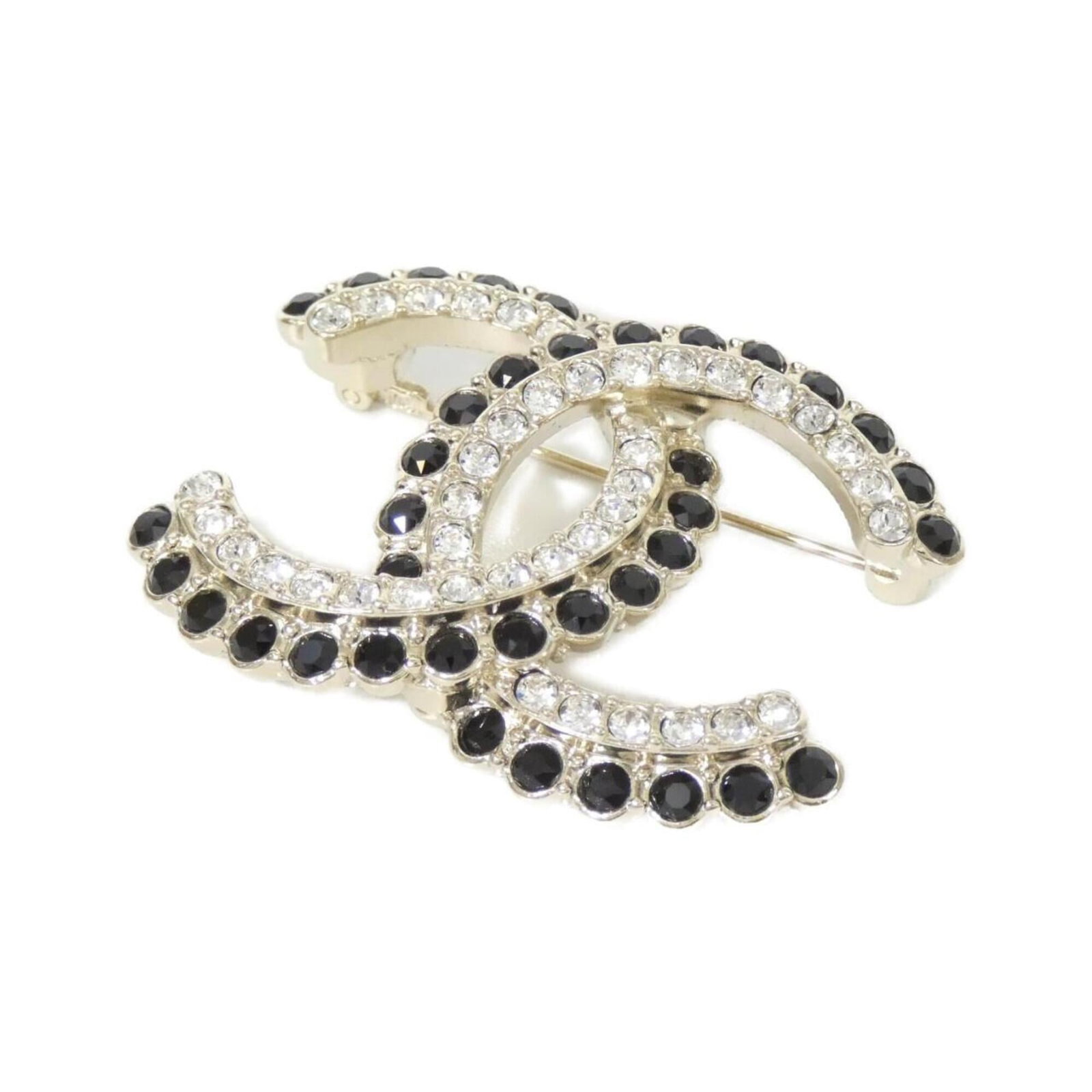 Brooch Chanel: Brooch Chanel Black and gold Chanel brooch features a crystal stone, measuring 3.5cm x 4.5cm in size. The sleek design showcases the luxurious materials and attention to detail characteristic of the