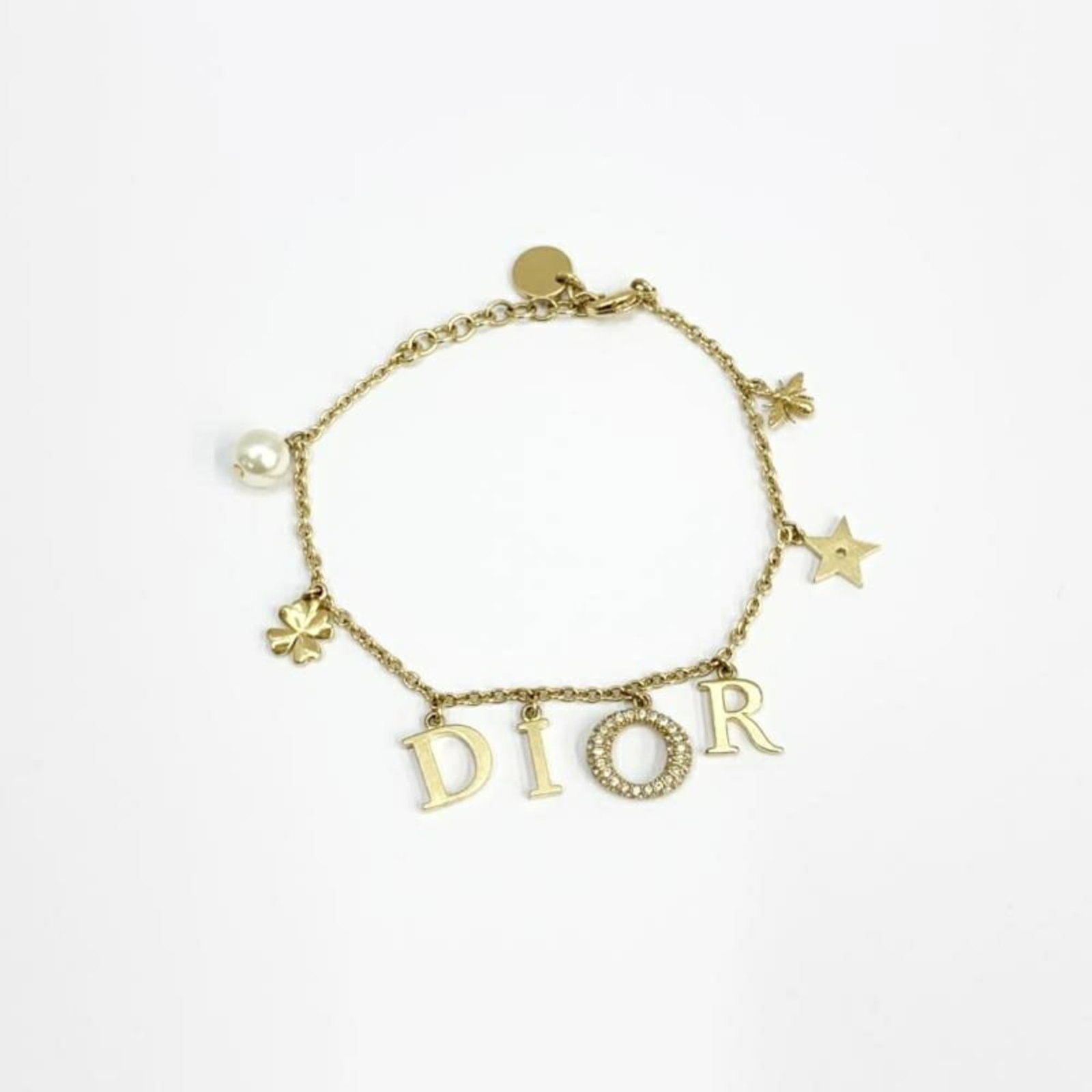 Christian Dior Charm bracelet: Christian Dior Charm bracelet The Christian Dior Charm bracelet boasts a sleek gold design, measuring 20cm in length. This elegant piece features the iconic brand's signature charm style, perfect for