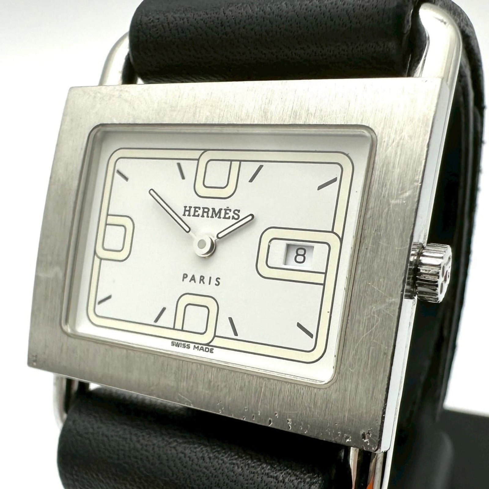 Hermes Wristwatch: Hermes Wristwatch Stainless steel case with a sleek white dial, the Hermes wristwatch boasts a classic design. Featuring a quartz movement and measuring 31mm in diameter, it's designed to fit wrists b