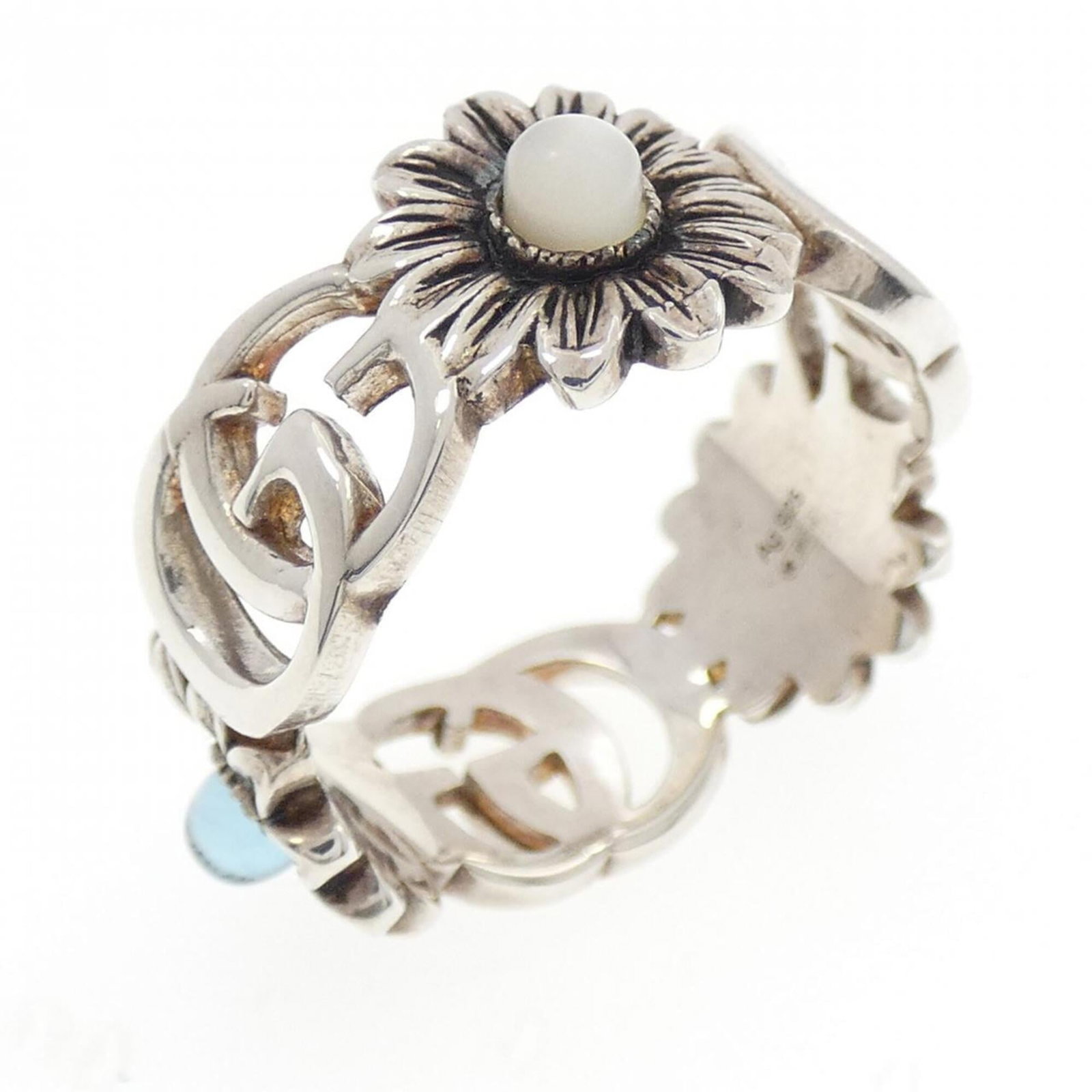 Gucci Band Ring Silver 925: Gucci Band Ring Silver 925 Silver band ring from Gucci, featuring mother of pearl and topaz stones. Made from high-quality silver 925 material, this elegant piece is a classic accessory for women.