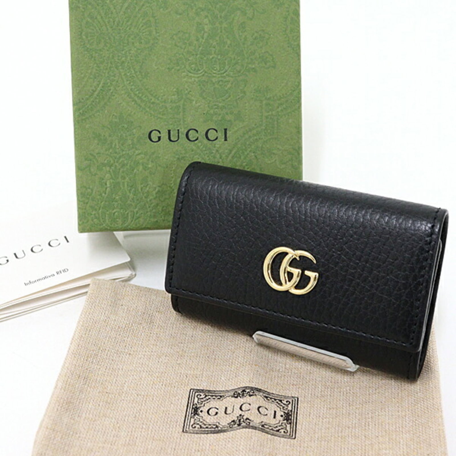 Keycase Leather by Gucci: Keycase Leather by Gucci Black leather keycase with box and dust bag, measuring 6cm x 9.5cm x 2cm. This Gucci keycase features high-quality leather construction and comes in a sleek black color. A sty