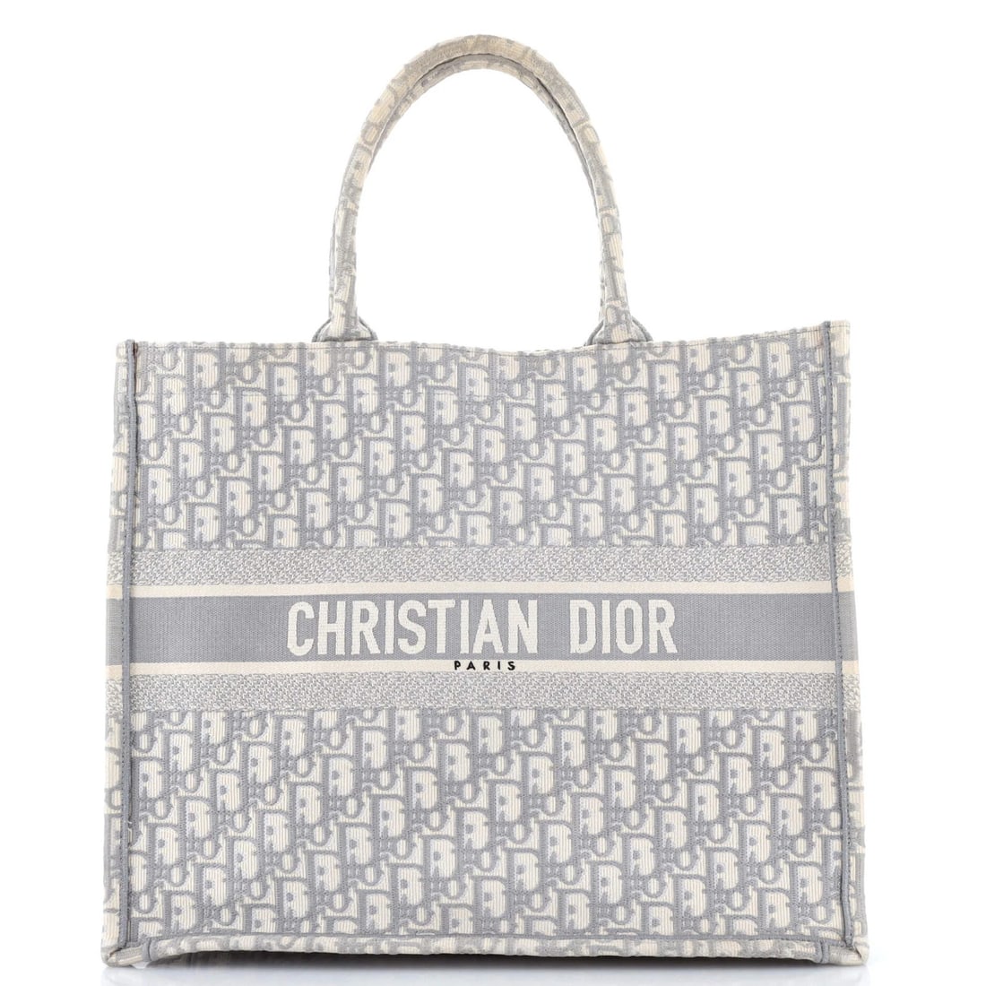 Christian Dior Book Oblique Canvas Large Tote: Christian Dior Book Oblique Canvas Large Tote Gray canvas tote bag with oblique design, measuring 13.5" tall and 16" wide, featuring a plain interior in matching gray color. The exterior shows signs