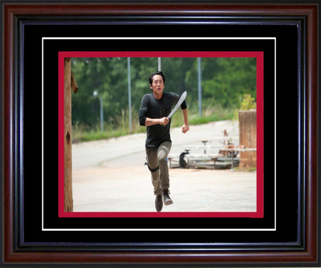 Steve Yuen Unsigned Framed Glenn Rhee Walking Dead 8x10 Photo: Steve Yuen Unsigned Framed Glenn Rhee Walking Dead 8x10 Photo Steve Yuen's 8x10 photo as Glenn Rhee from The Walking Dead is framed in a cherry wood frame with black on red matte board. This photo fea
