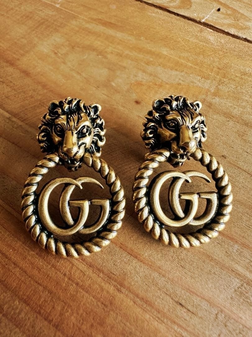 Gold Double G Dangle Lion Head Gucci GG Earrings: Gold Double G Dangle Lion Head Gucci GG Earrings Item Specifics: Brand: Gucci Type: Earrings Closure: Dangle Color: Gold Style: Clip on Material: Metal Product Disclaimer: Items may exhibit light wear