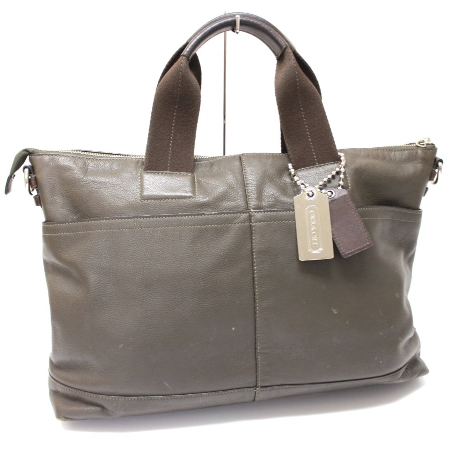 Leather tote bag by coach: Leather tote bag by coach Green leather tote bag by Coach, measuring 39.5cm x 29.5cm x 10cm in size, features a classic design with clean lines and a timeless aesthetic. The bag's green color adds a p