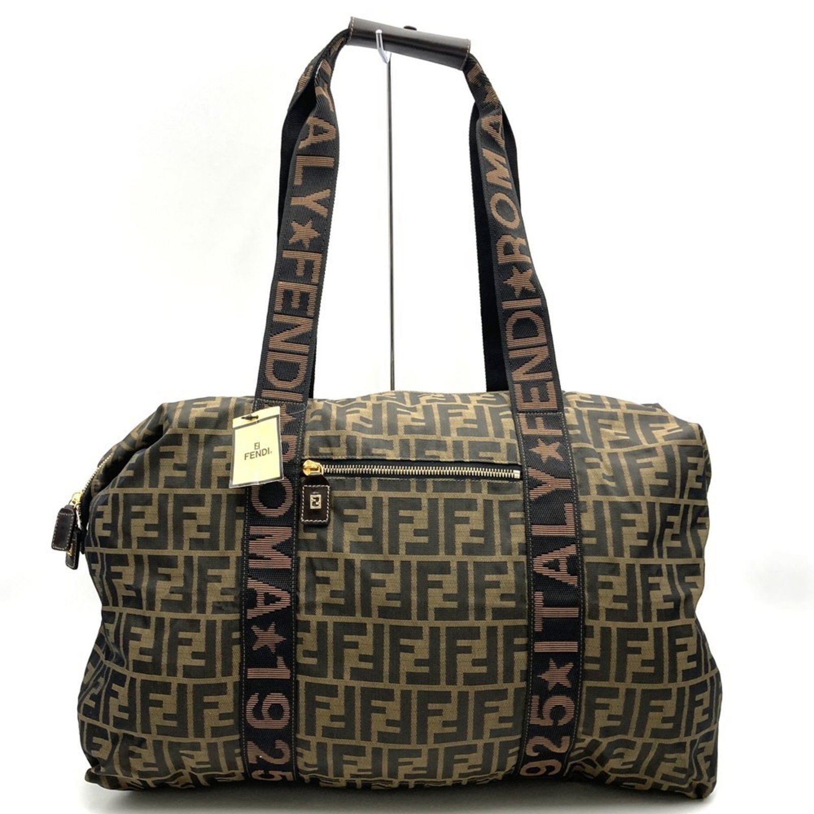Boston Bag Zucca by Fendi: Boston Bag Zucca by Fendi The Boston Bag Zucca by Fendi boasts sleek, modern design with a rich brown hue and silver hardware. This stylish tote features a spacious interior with a zippered pocket for