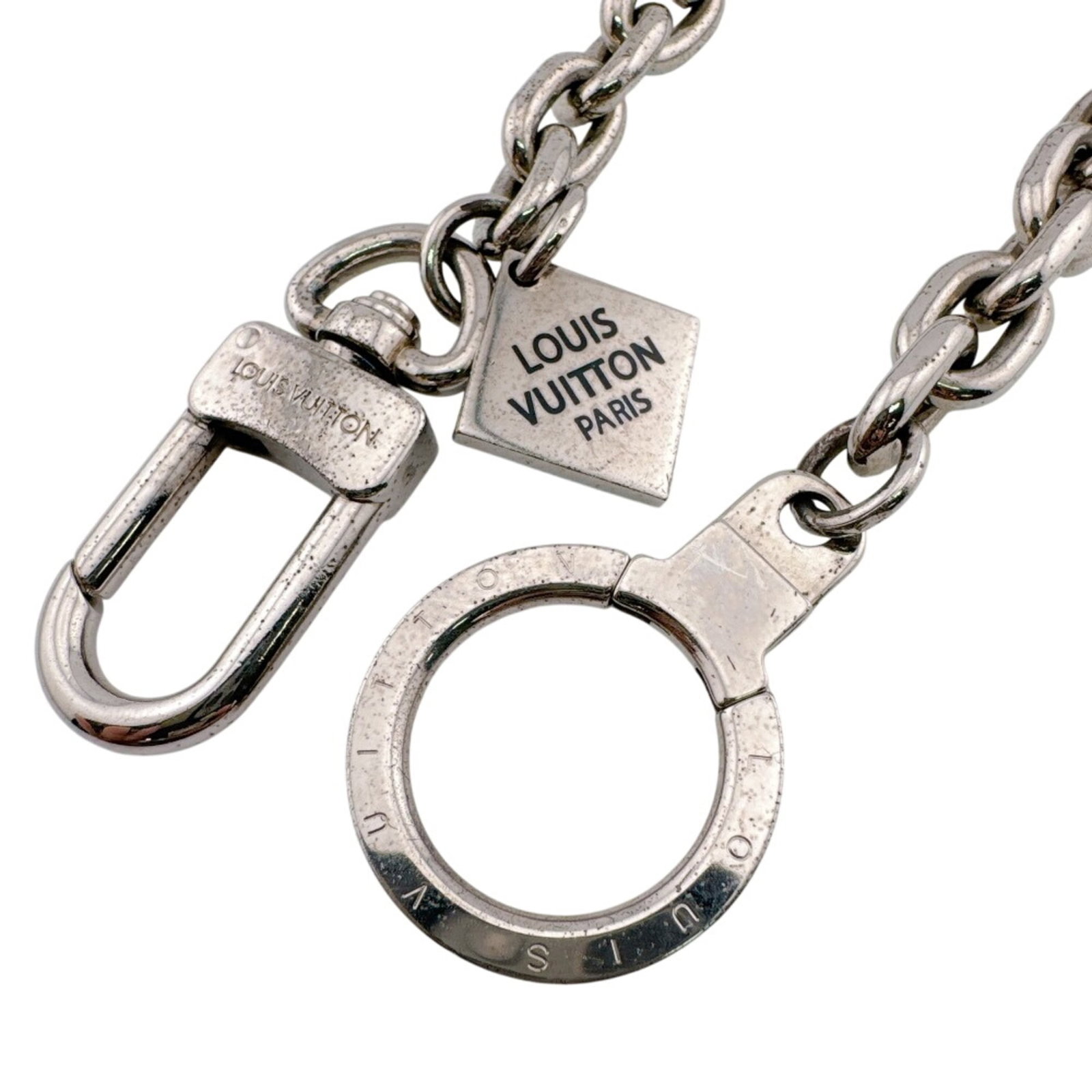 Metal keyring by Louis Vuitton: Metal keyring by Louis Vuitton Silver metal keyring by Louis Vuitton, measuring 1cm x 40.5cm in size, bears the signature of the brand. This keyring showcases a sleek and modern design characteristic 