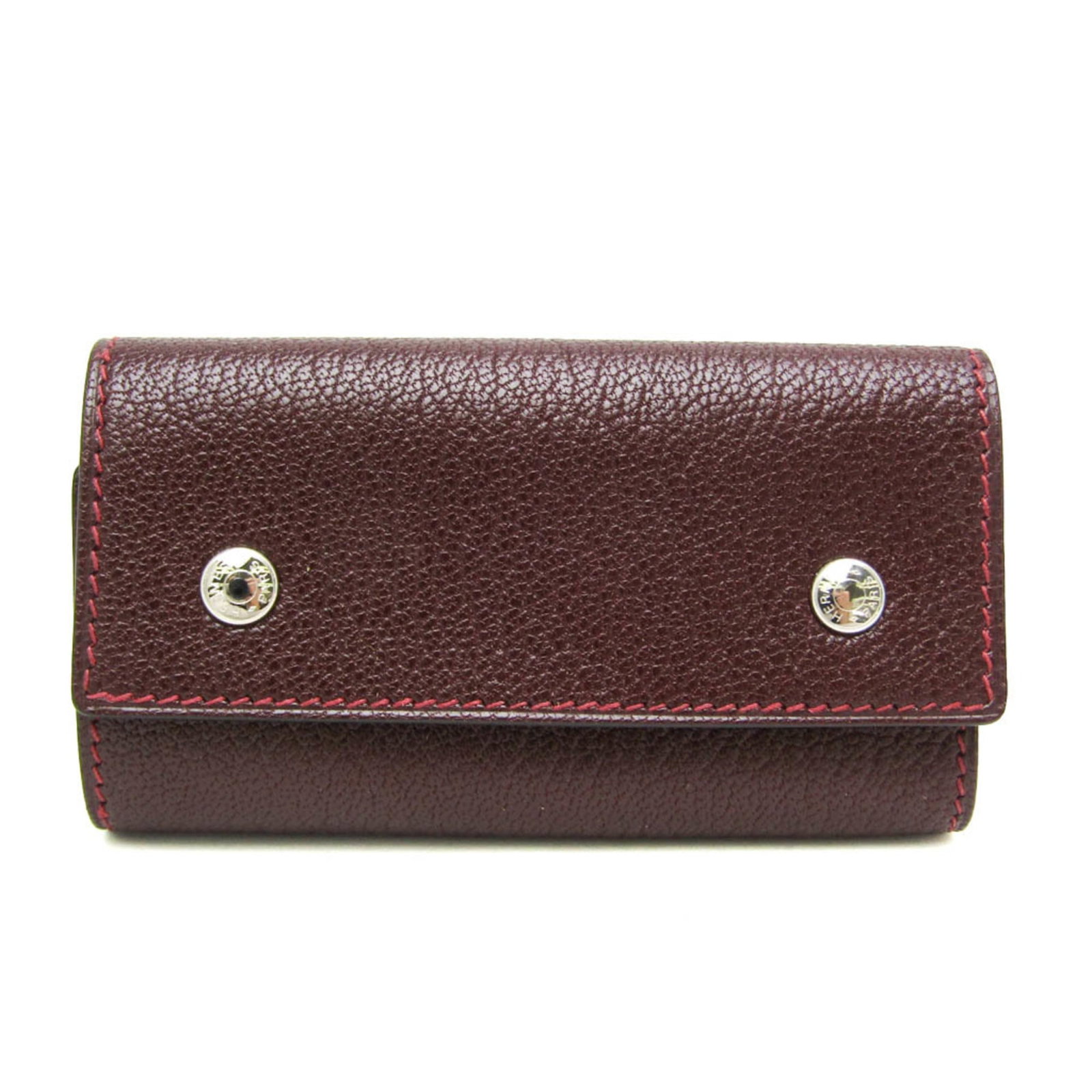 Chevre leather keycase by Hermes: Chevre leather keycase by Hermes The Chevre leather keycase by Hermes boasts sleek, sophisticated design with its wine-colored exterior. Made from high-quality chevre leather, this compact keycase
