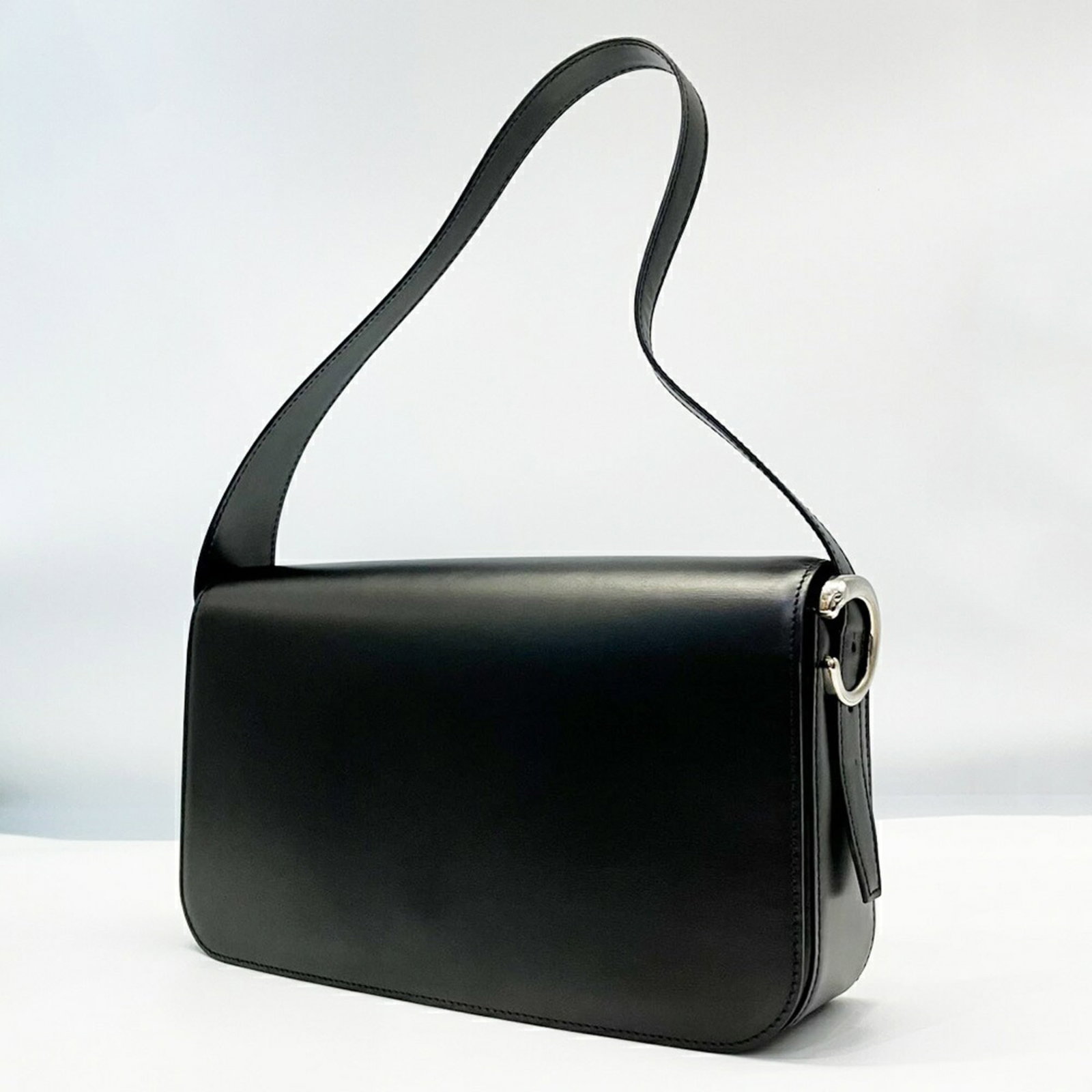Shoulder Bag Leather by Cartier: Shoulder Bag Leather by Cartier Cartier's Panthre shoulder bag is crafted from high-quality black leather, featuring a classic design with clean lines and a timeless aesthetic. Measuring 15cm x 26cm x