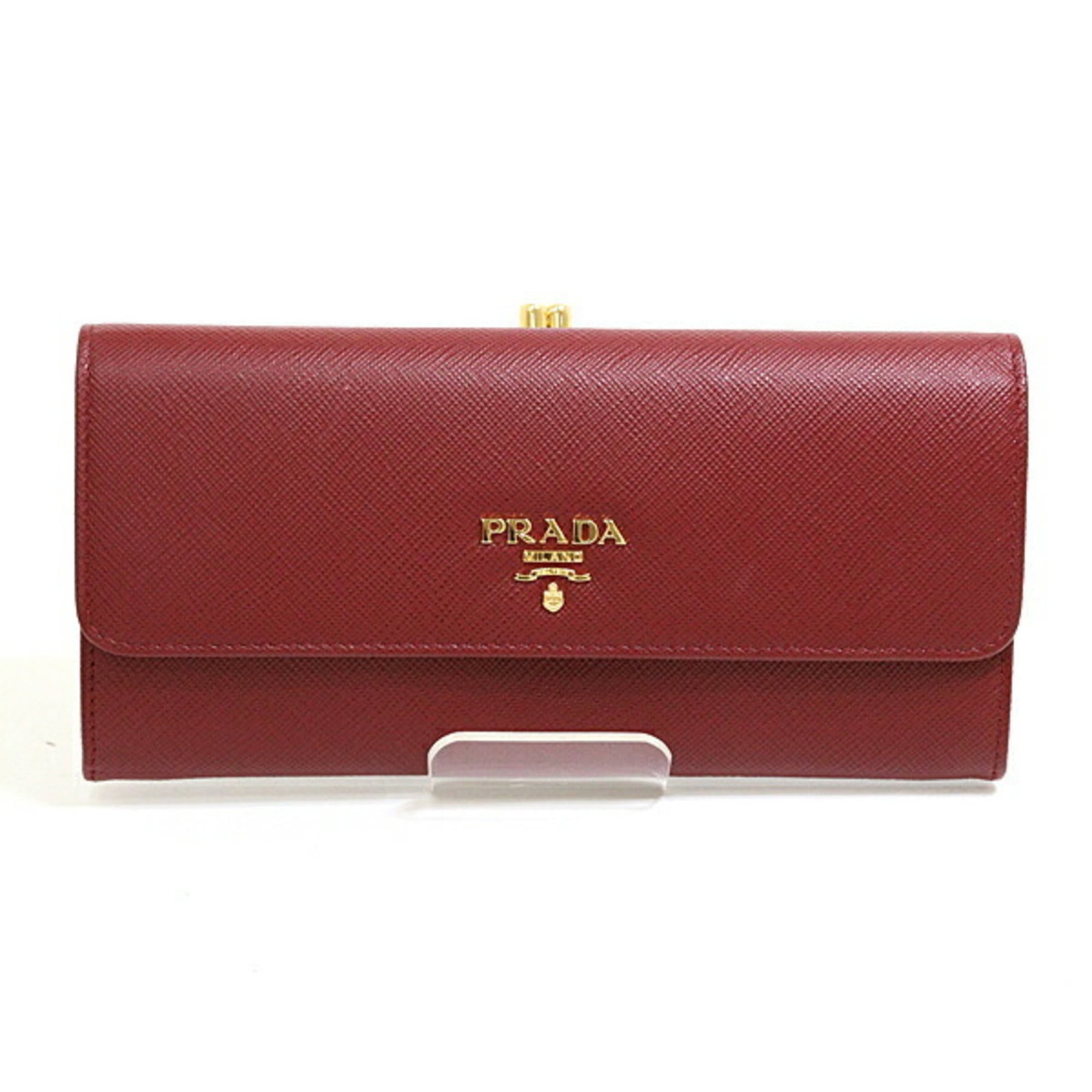 Long Wallet Saffiano Bi Fold Prada: Long Wallet Saffiano Bi Fold Prada Saffiano leather construction provides durability and sophistication to this Bordeaux-colored bi-fold wallet, measuring 9cm x 18.8cm x 3.2cm. The Prada brand's signa