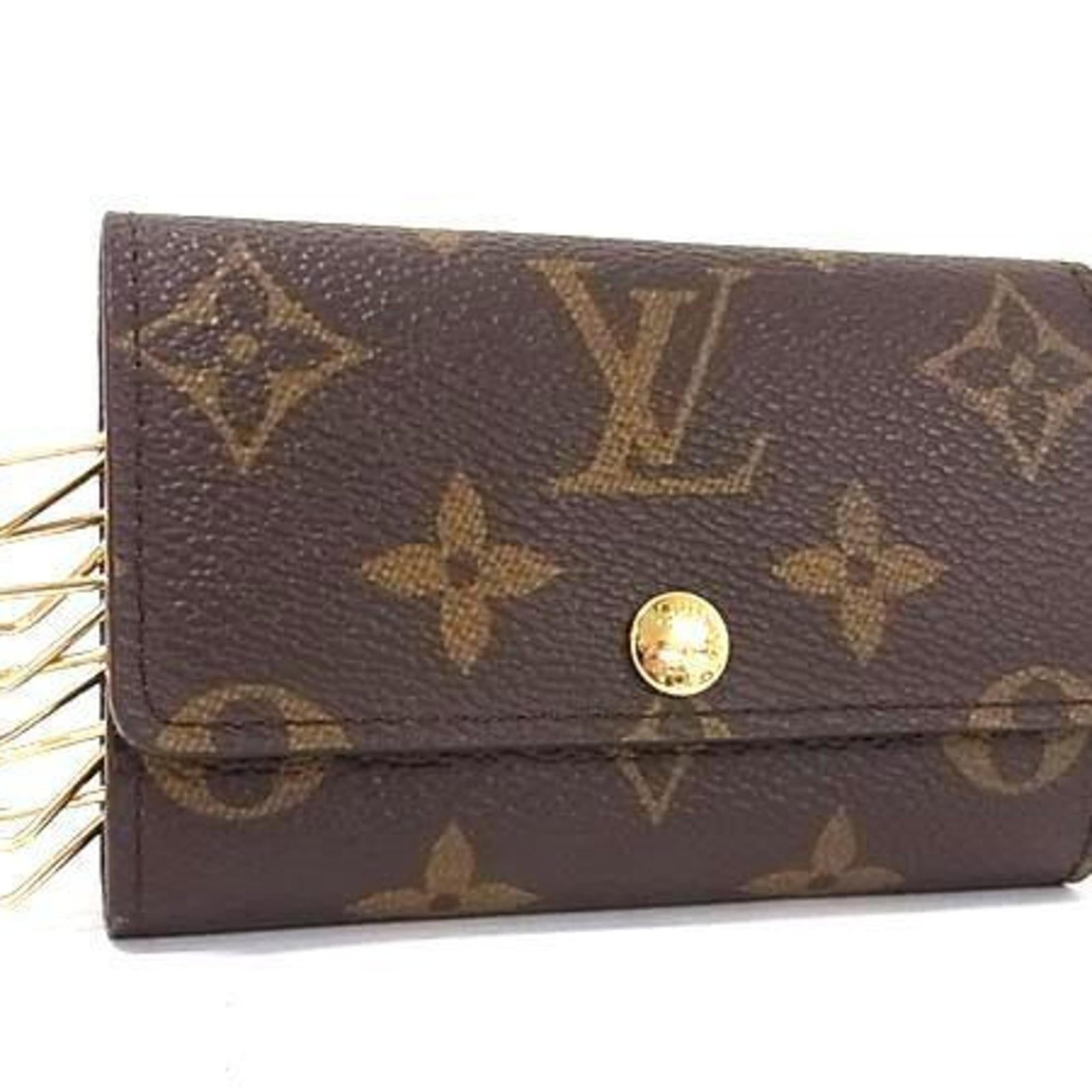 Keycase Monogram Louis Vuitton: Keycase Monogram Louis Vuitton Monogrammed with iconic Louis Vuitton style, this brown keycase features six secure key hooks and a compact design. Made from high-quality monogram material, it measures