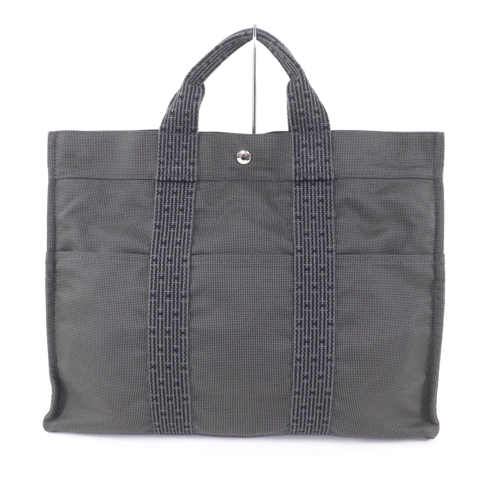 Polyester polyamide bag tote by Hermes: Polyester polyamide bag tote by Hermes Polyester polyamide bag tote by Hermes features a sleek gray color and durable construction, measuring 31.5cm x 42cm x 11.5cm. Made from high-quality polyester a