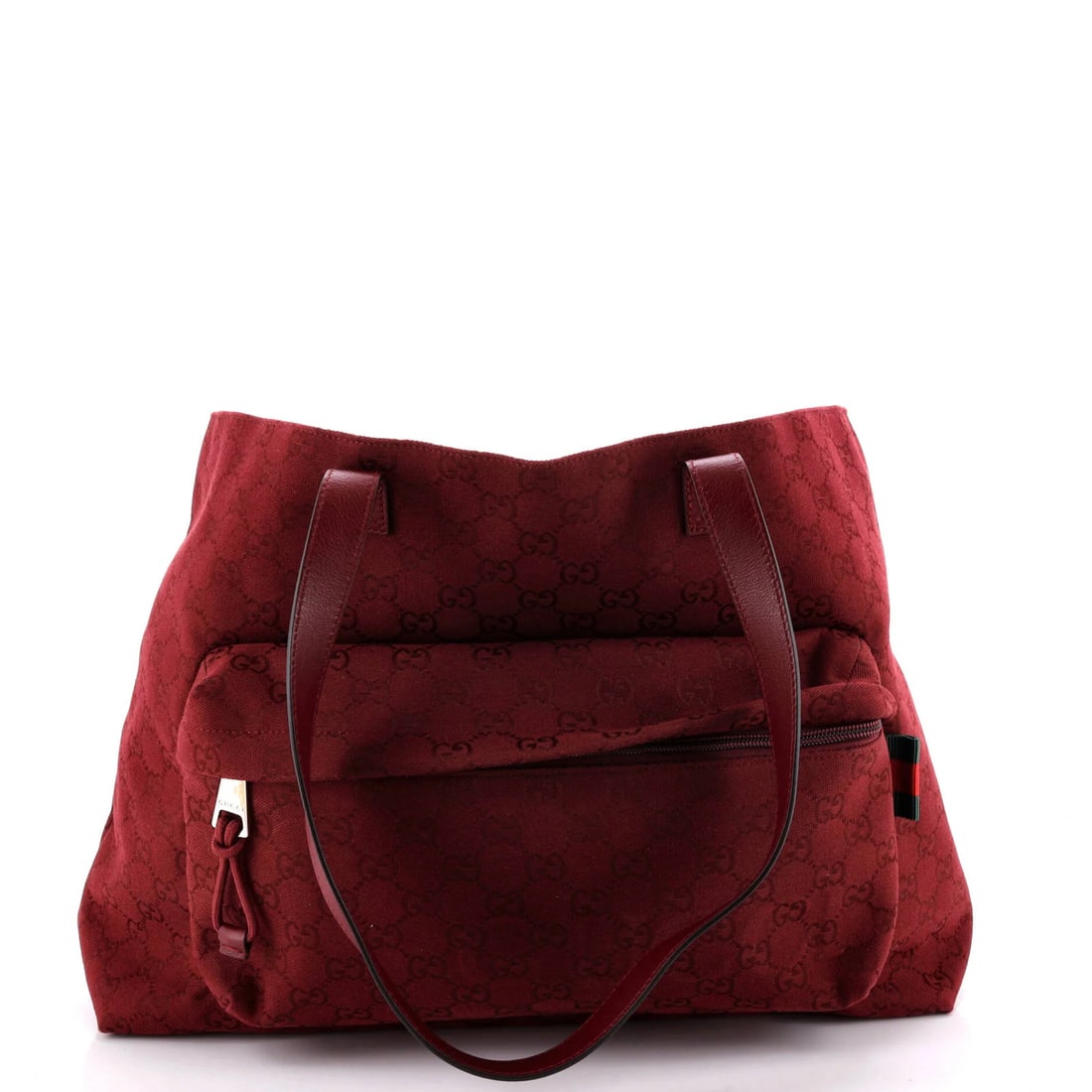 Front Pocket Debossed Logo Tote Large GG: Front Pocket Debossed Logo Tote Large GG Red canvas tote bag with front pocket and debossed logo, featuring silver hardware and minor scuffs on exterior. The interior is lined with red nylon, adding a