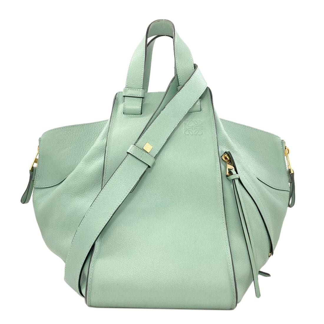 Handbag Calf Hammock 2Way Loewe: Handbag Calf Hammock 2Way Loewe Handbag Calf Hammock 2Way Loewe features a green exterior made from calf material, showcasing a distinctive style and color. The notable design element of the 2Way cons
