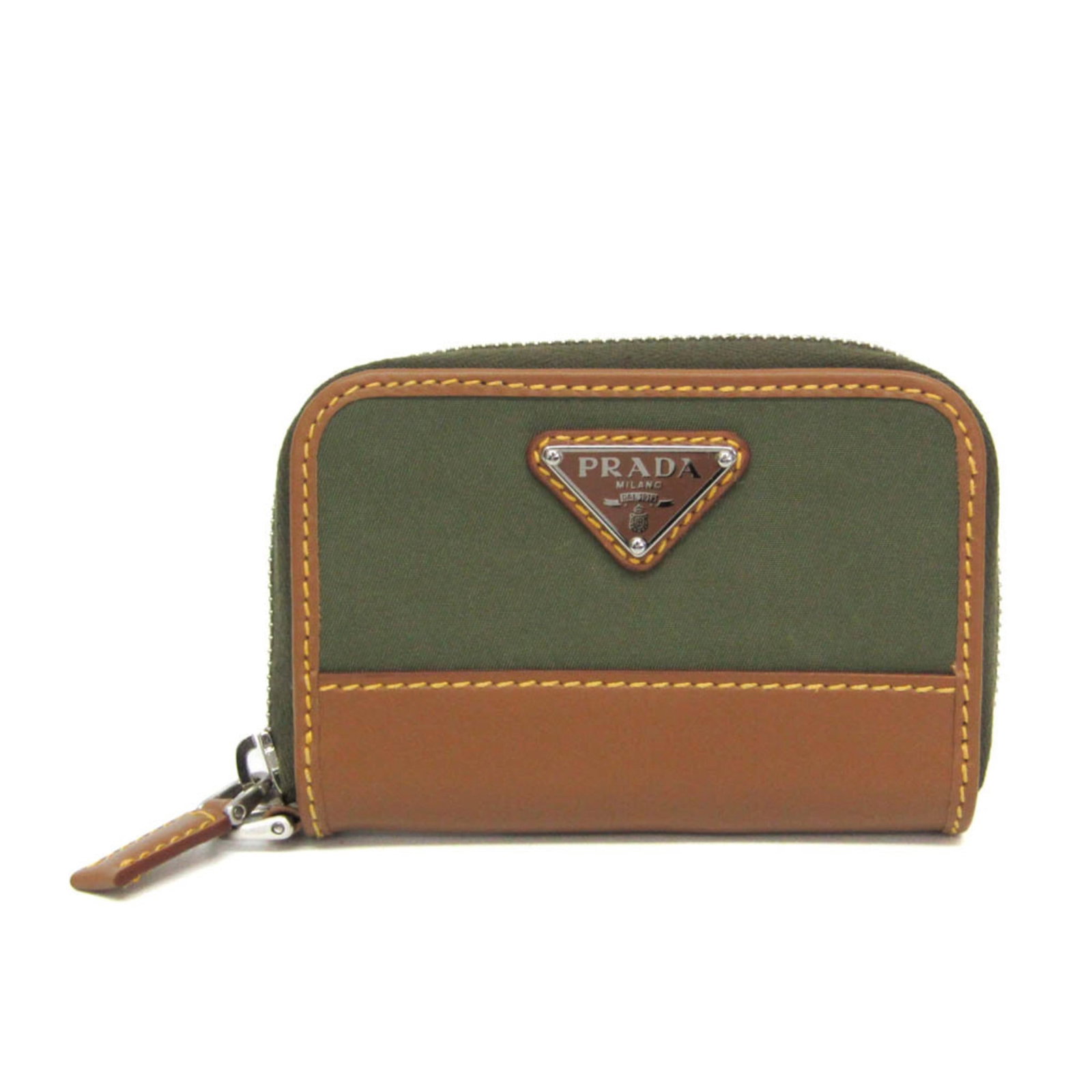 Prada Coin Purse/ Coin Case Nylon Leather: Prada Coin Purse/ Coin Case Nylon Leather Nylon and leather blend in a timeless design, the Prada RE-NYLON Coin Card Holder offers a chic and functional way to carry coins. With a khaki or light brown