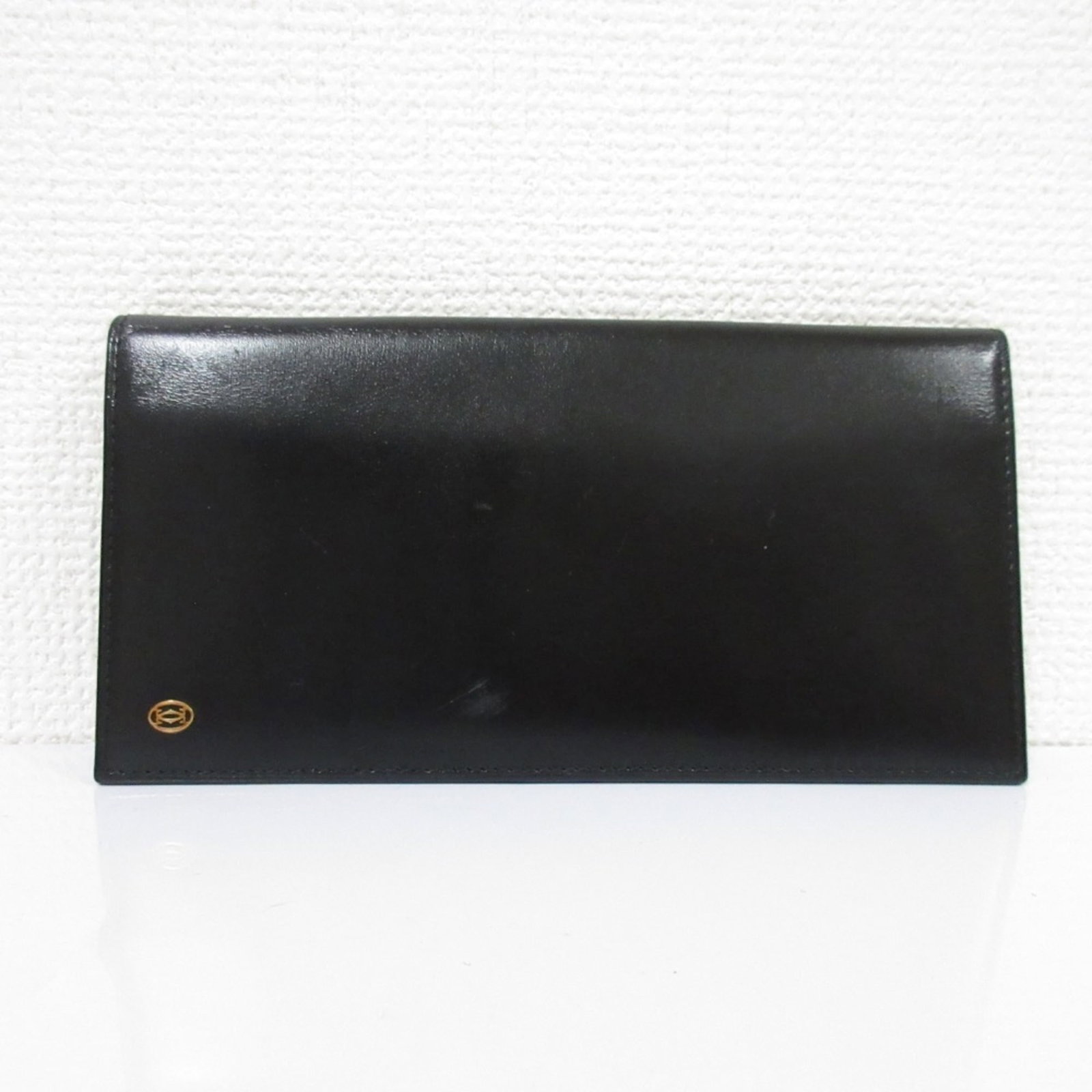 Long wallet leather bi-fold cartier: Long wallet leather bi-fold cartier Cartier long wallet features black leather construction with a bi-fold design, measuring 9.2cm x 18cm x 1cm. The sleek and classic style makes it a versatile access
