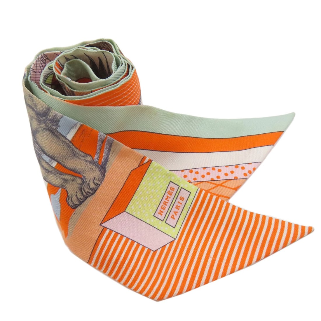 Hermes Twilly Silk Scarf: Hermes Twilly Silk Scarf Orange silk scarf from the renowned brand HERMES, featuring a classic Twilly design. Made from high-quality silk, this scarf boasts a vibrant orange exterior color that adds a