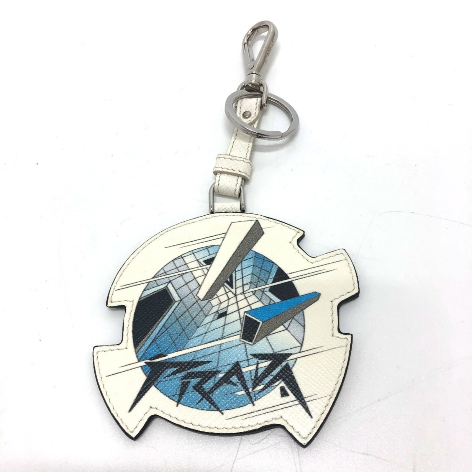 Prada Keyring Leather: Prada Keyring Leather Prada Keyring Leather is made from high-quality leather and features a sleek design. The keyring measures 8.5cm x 9cm x 2.00mm, making it a compact accessory. It comes in white a