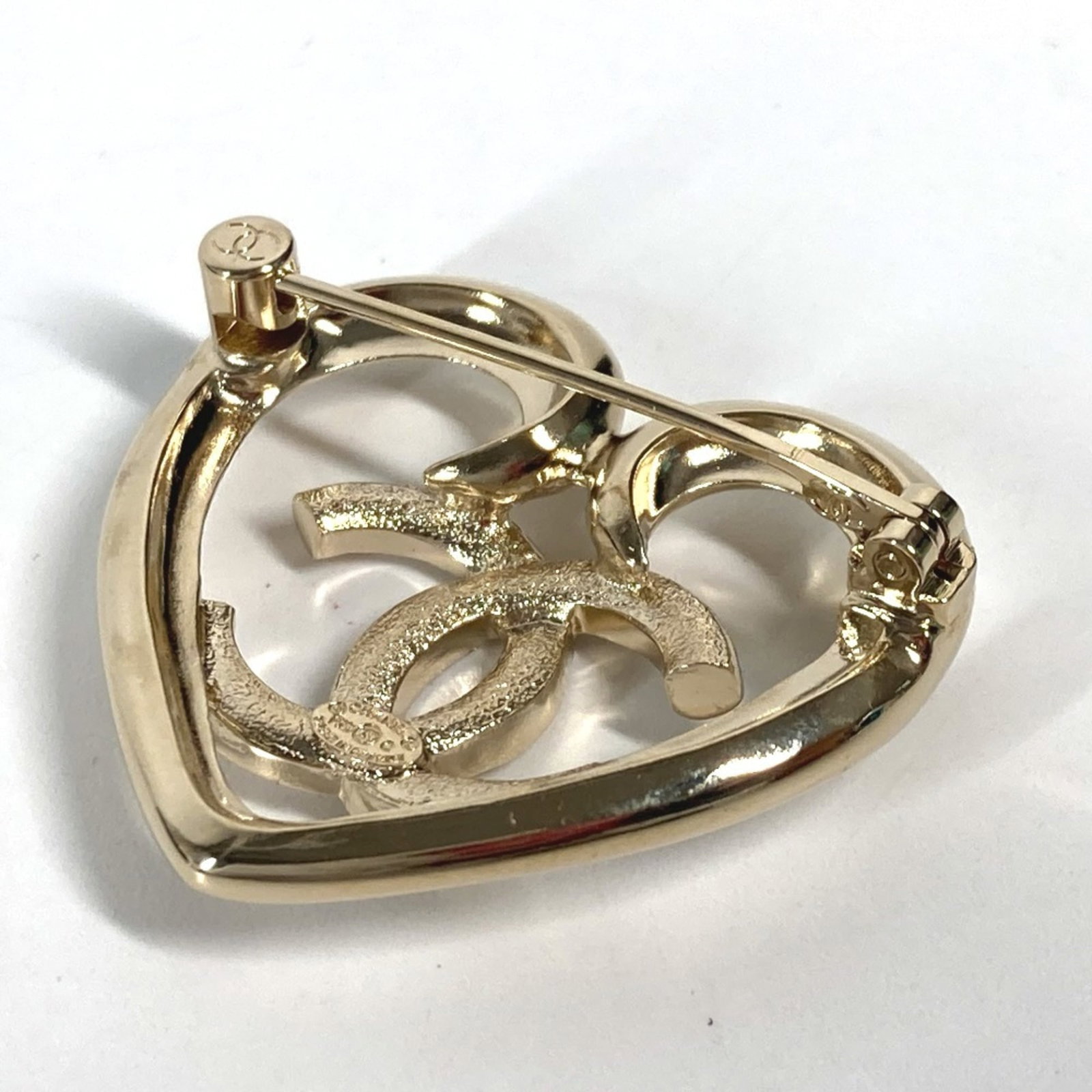 Metal brooch by Chanel: Metal brooch by Chanel Metal brooch by Chanel, featuring gold metal and rhinestone details. This elegant piece measures 3.2cm x 3.5cm / 1.25'' x 1.37''. Comes in a box. Item Specifics: Brand: Chanel