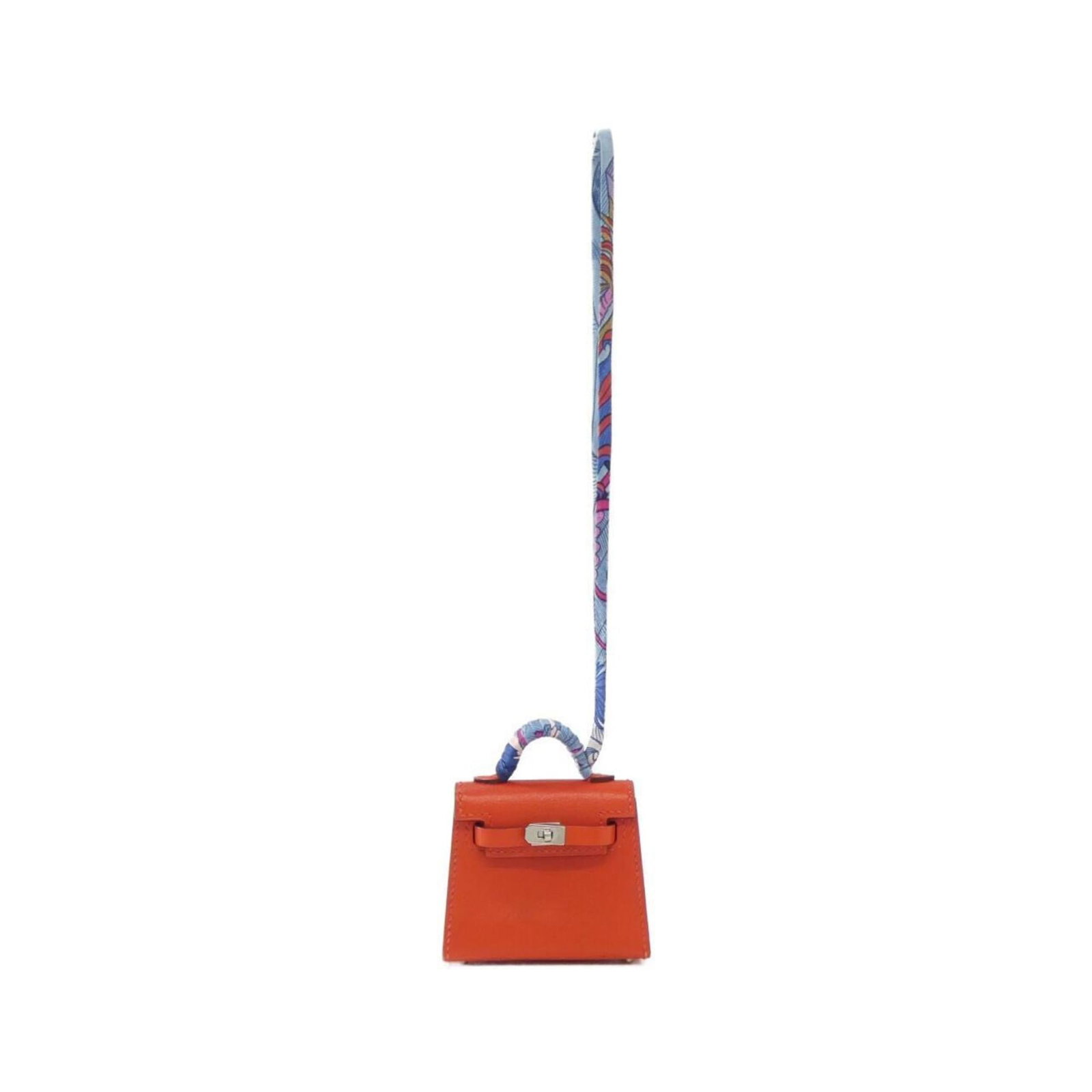 Handbag Charm Silk Tadelakt Leather by Hermes: Handbag Charm Silk Tadelakt Leather by Hermes Silk and Tadelakt leather come together in this unique handbag charm from Hermes, featuring a striking Capucine color. The combination of these materials 