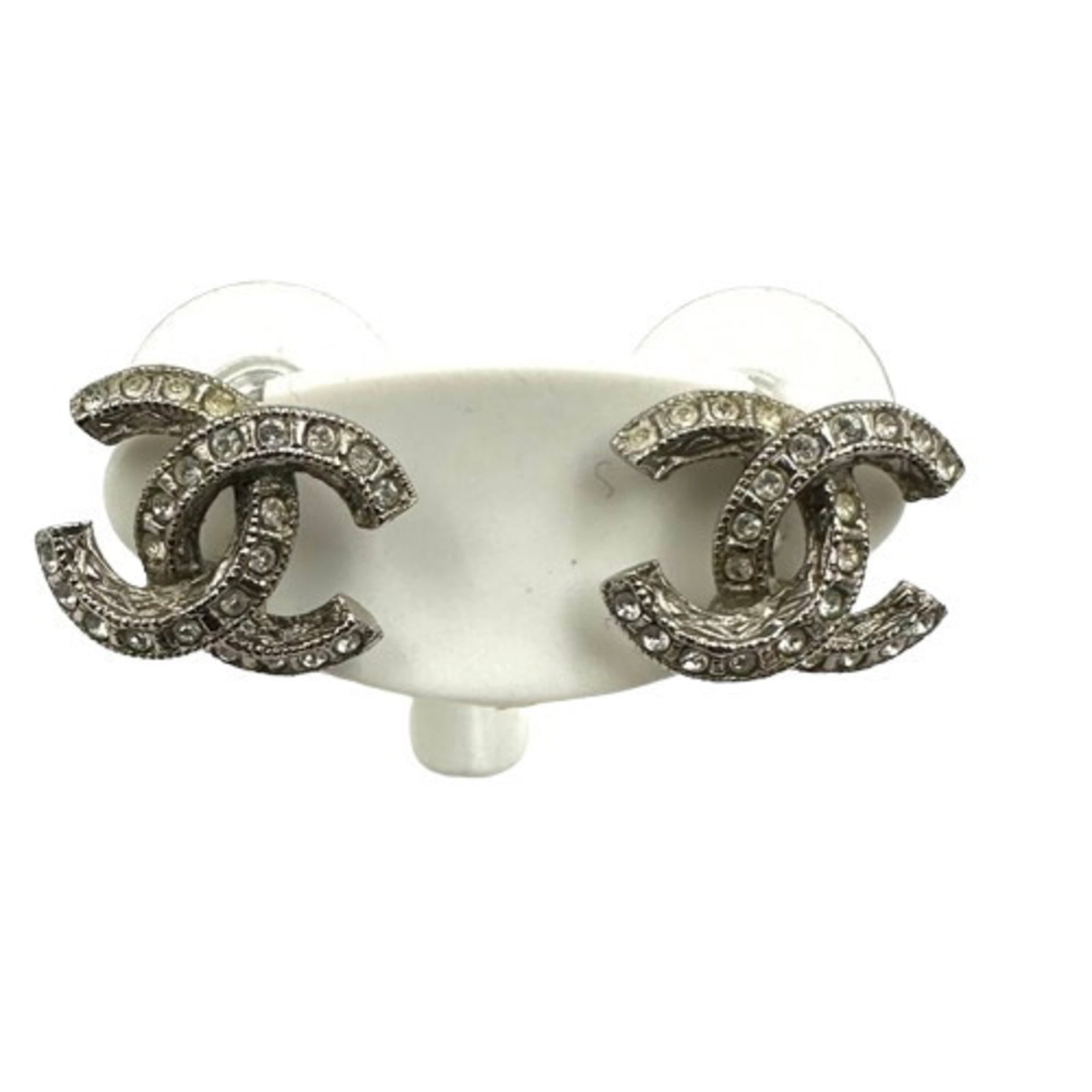Metal earrings by Chanel: Metal earrings by Chanel Metal earrings by Chanel, featuring gold plated metal and rhinestone details in a silver finish. The stud earrings measure 10mm x 12mm x 0.39'' x 0.47''. They bear the signatu