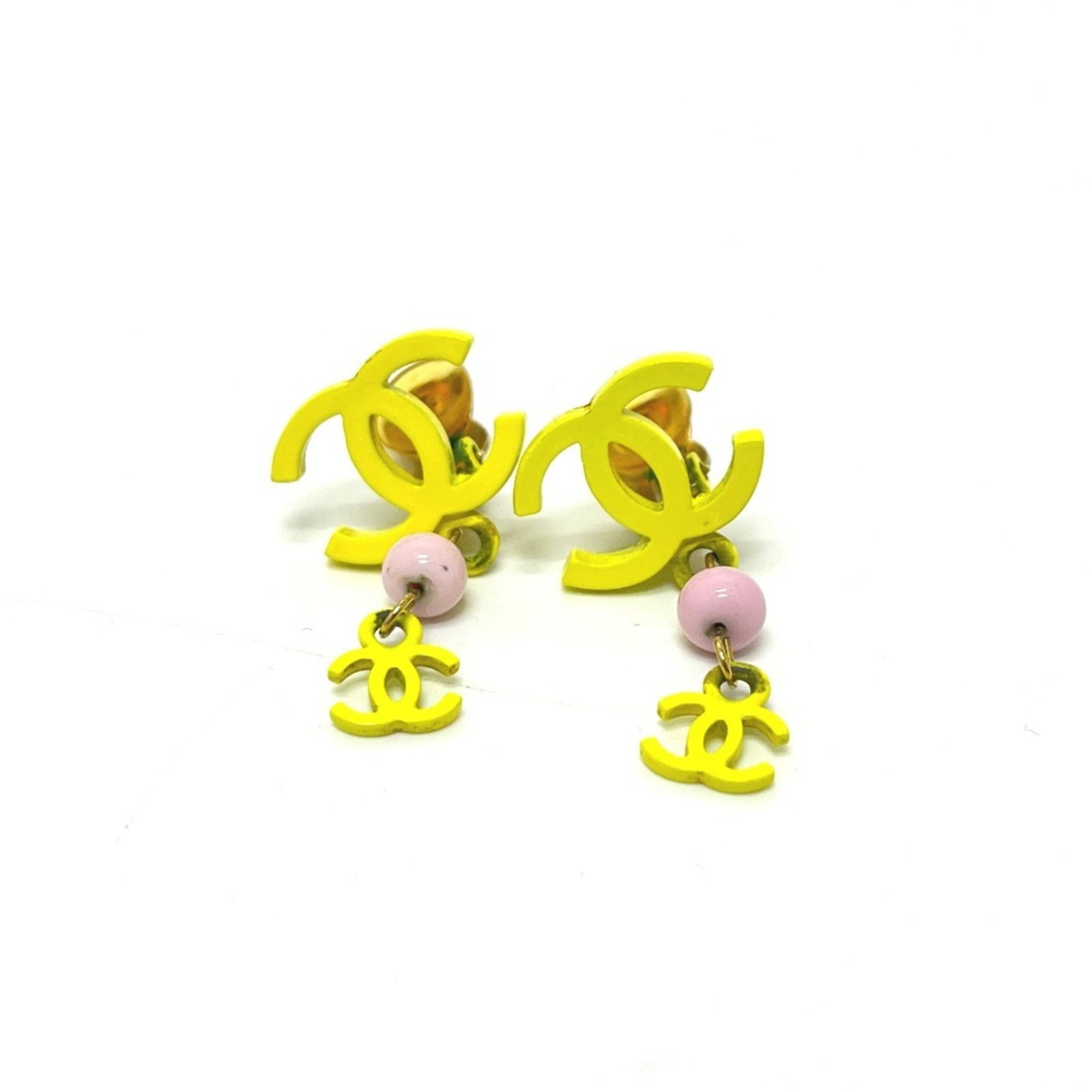 Metal clip earrings by Chanel: Metal clip earrings by Chanel Pink and yellow metal clip earrings by Chanel, measuring 35.00mm x 18.00mm in size. These clip earrings showcase the iconic design of the French fashion house. Made from 