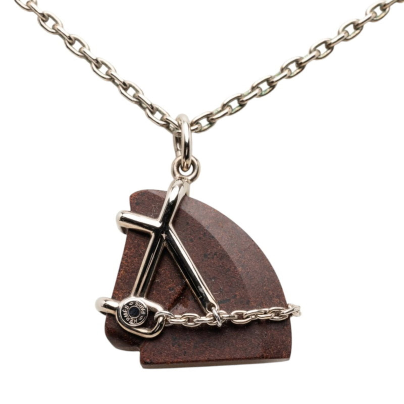 Women's silver and brown metal horse motif pendant necklace by Hermes.: Women's silver and brown metal horse motif pendant necklace by Hermes. Women's silver and brown metal horse motif pendant necklace by Hermes features a striking design with intricate details. The neck