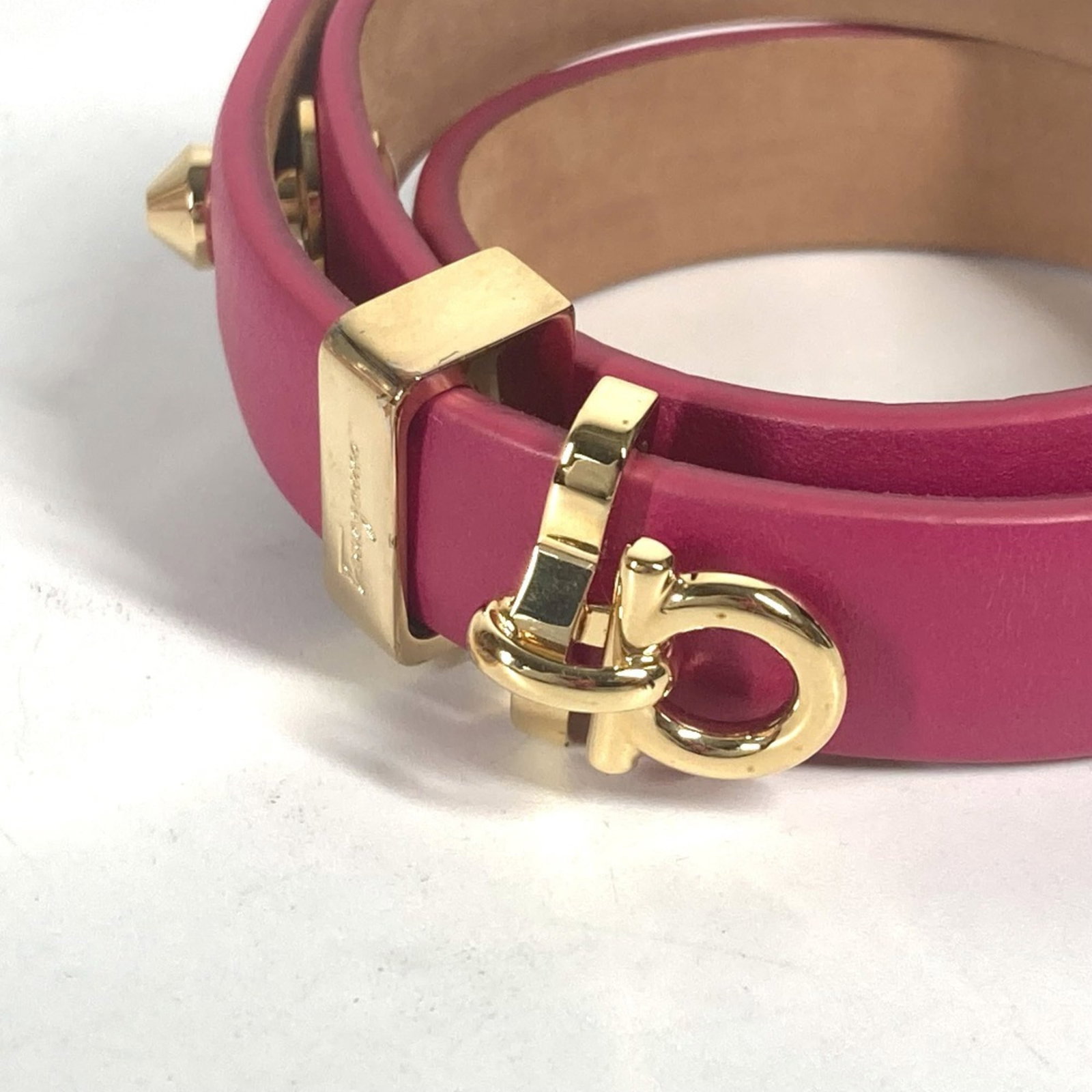 Ferragamo Charm Leather Bracelet Salvatore: Ferragamo Charm Leather Bracelet Salvatore Salvatore Ferragamo's Charm Leather Bracelet boasts a sleek design with gold and pink hues, measuring 39.5cm in length. This elegant accessory comes complete