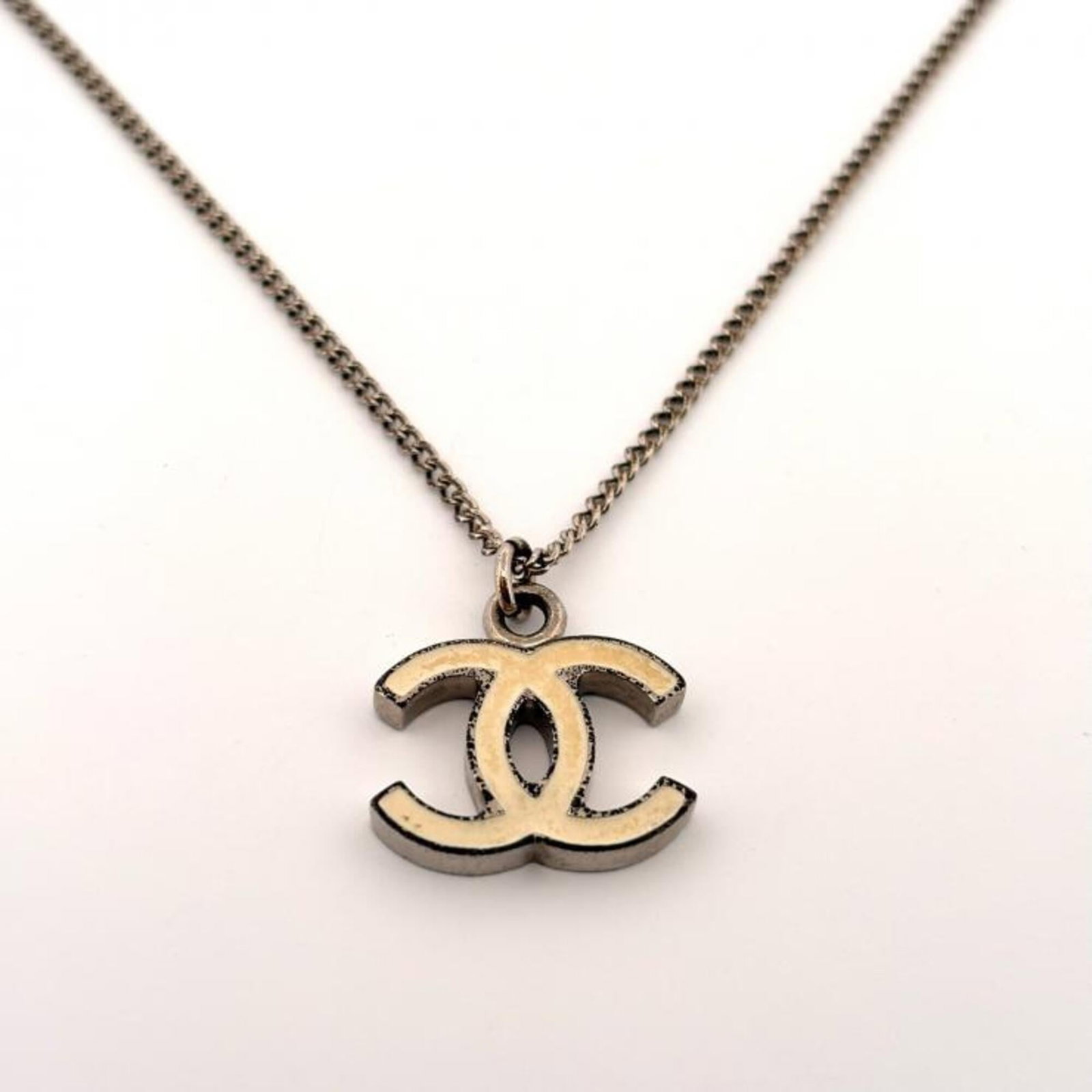 Chanel Necklace Coco Mark 07V Metal Silver Off-White Cc Reversible.: Chanel Necklace Coco Mark 07V Metal Silver Off-White Cc Reversible. Off-white and silver Chanel Necklace Coco Mark 07V boasts a reversible design, offering versatility to the wearer. The necklace feat
