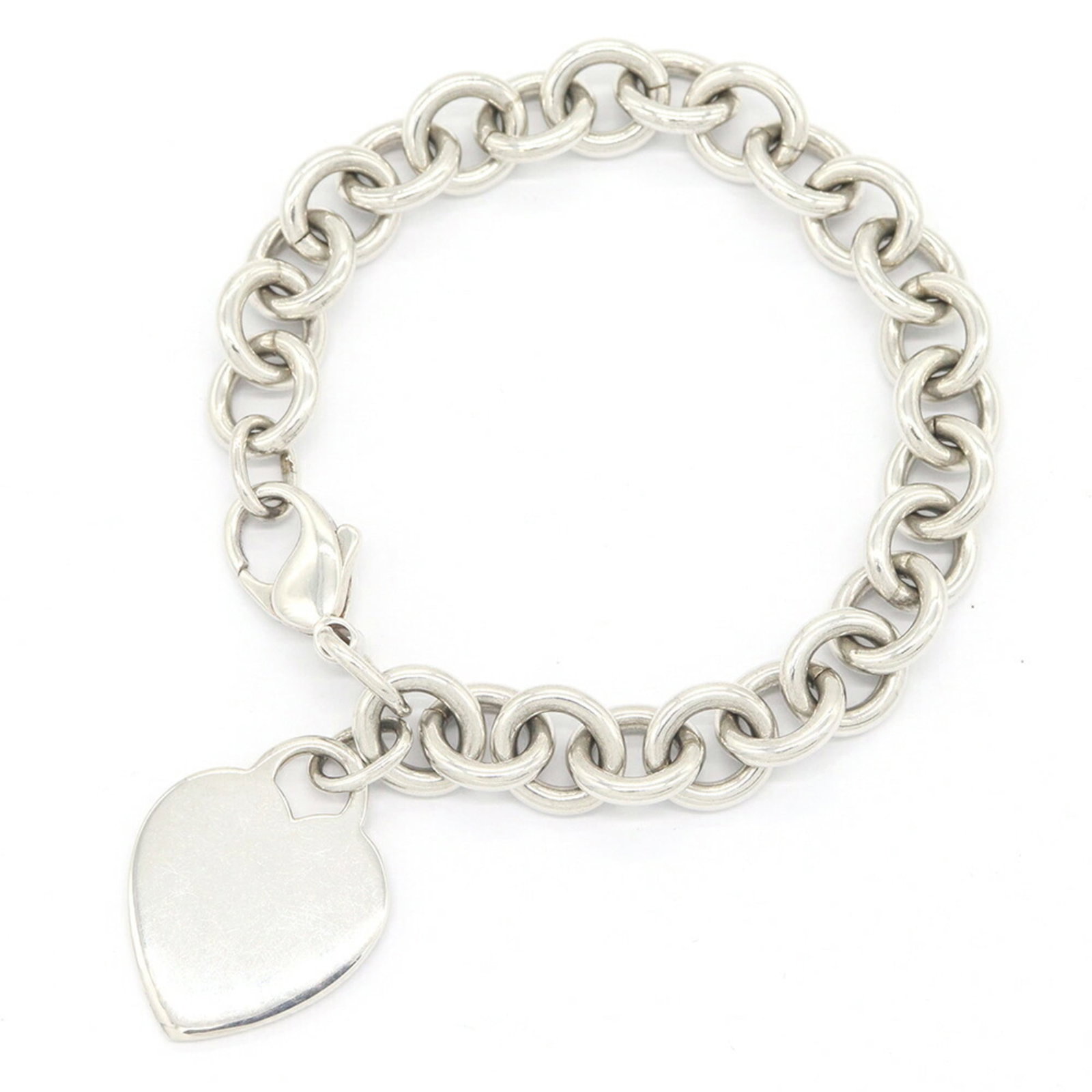 Sterling silver charm bracelet by Tiffany.: Sterling silver charm bracelet by Tiffany. Sterling silver charm bracelet by Tiffany, featuring a delicate design with intricate details and a signature. This elegant piece measures 17cm in length and