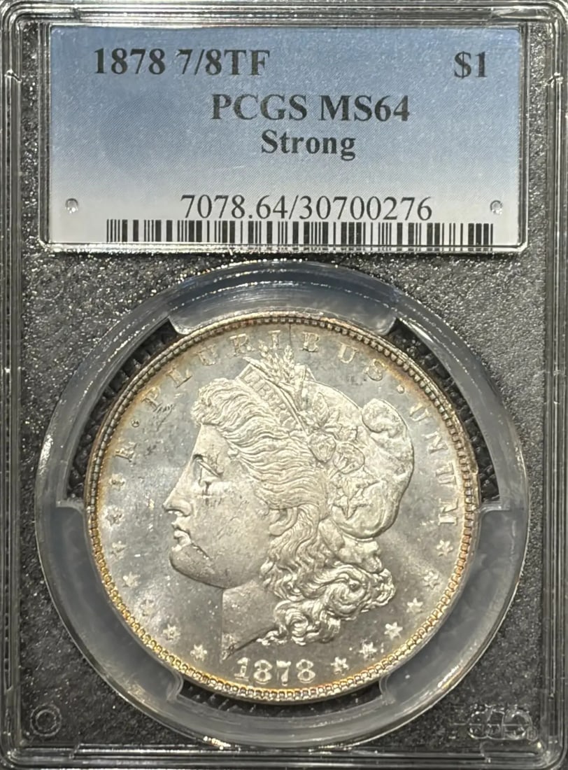 1878 7/ 8TF STRONG MORGAN DOLLAR PCGS MS64: 1878 7/ 8TF STRONG MORGAN DOLLAR PCGS MS64 The 1878 Morgan Dollar, graded MS64 by PCGS, boasts a rich history as one of the most iconic coins in American numismatics. This uncirculated specimen showca