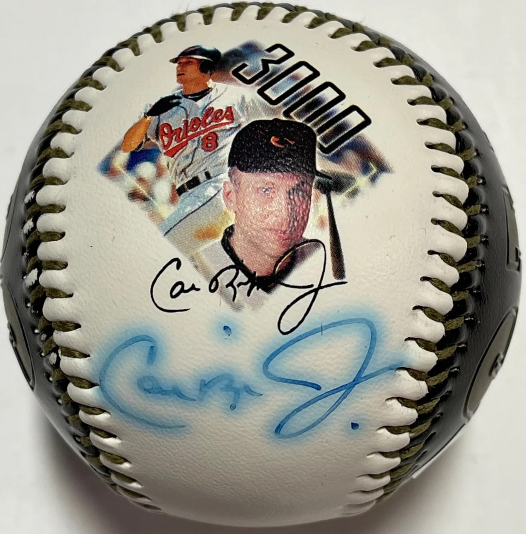 Cal Ripken Jr Autographed 3000 Hit Commemorative Photo Baseball (Ironclad): Cal Ripken Jr Autographed 3000 Hit Commemorative Photo Baseball (Ironclad) Cal Ripken Jr's historic 3000th hit commemorated on this official MLB baseball, signed in blue pen across the side panel unde
