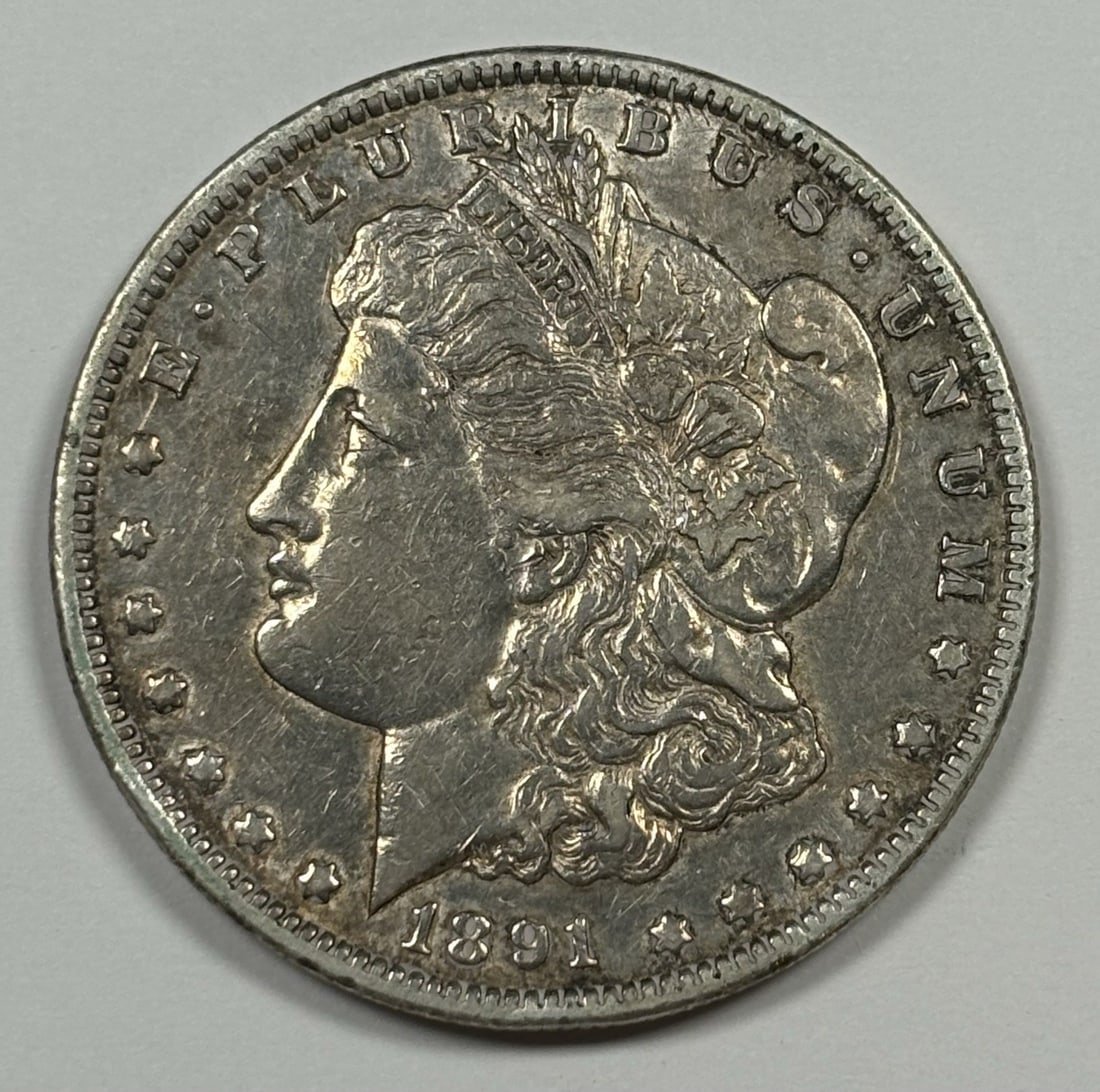 CC MORGAN DOLLAR 1891 XF AU: CC MORGAN DOLLAR 1891 XF AU The CC Morgan Dollar, minted in 1891, boasts an XF AU grade, indicating exceptional condition with minor wear. This circulated coin features a silver composition and bears 