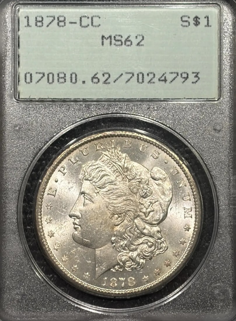 1878-CC MORGAN DOLLAR PCGS MS62 RATTLER OGH: 1878-CC MORGAN DOLLAR PCGS MS62 RATTLER OGH The 1878-CC Morgan Dollar PCGS MS62 Rat-tler OGH is a highly graded uncirculated coin, certified by the Professional Coin Grading Service (PCGS) with a grad