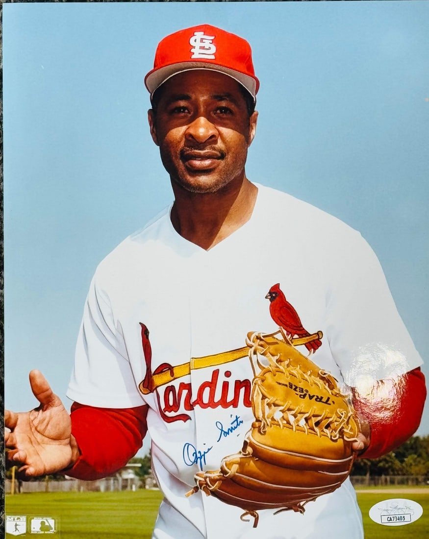 Smith Ozzie Autographed Baseball Photo JSA: Smith Ozzie Autographed Baseball Photo JSA Signed in blue sharpie across the front of an official 8x10 baseball photo, Ozzie Smith's mark adds a touch of nostalgia to this unique piece. The James Spen