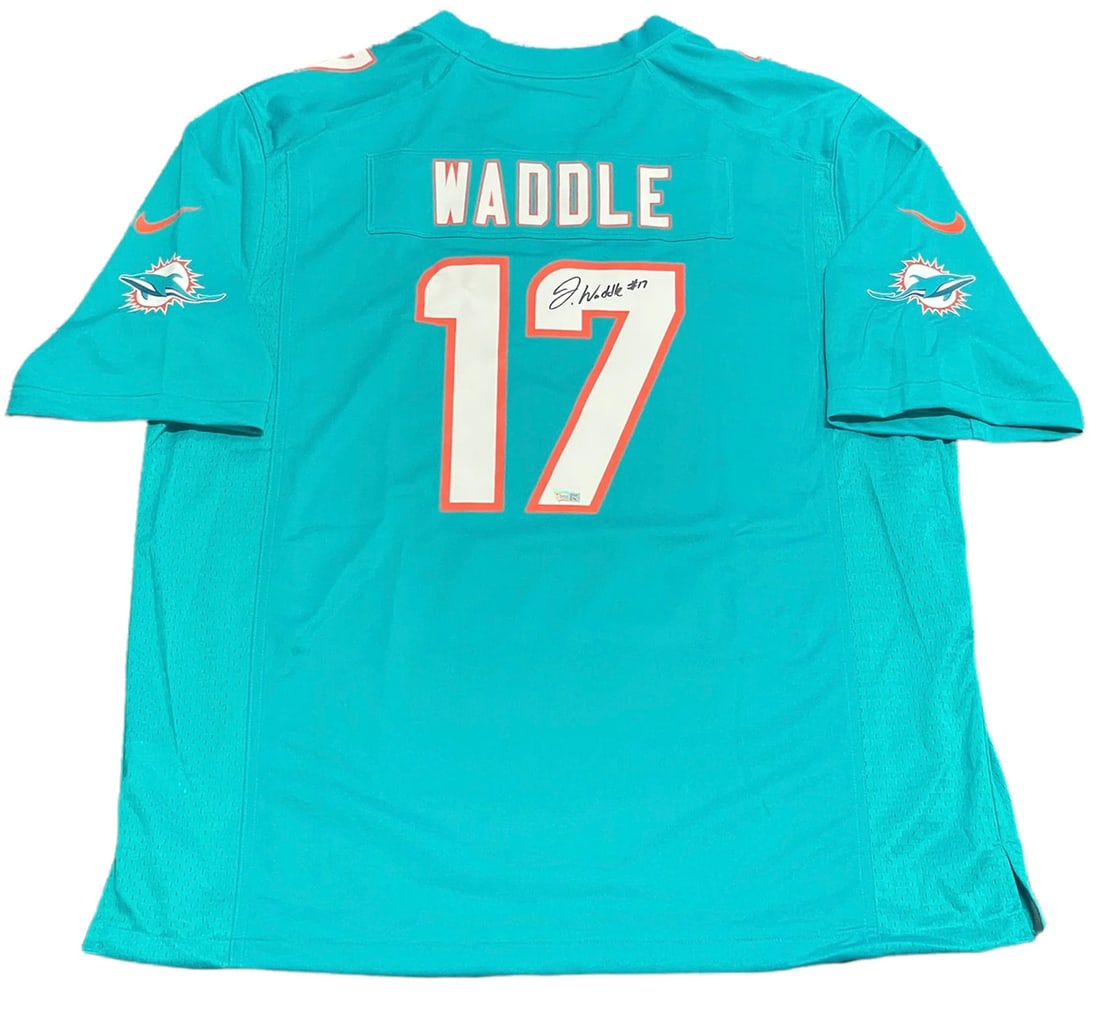Jaylen Waddle Autographed Dolphins Aqua Jersey (Fanatics): Jaylen Waddle Autographed Dolphins Aqua Jersey (Fanatics) Authentic Jaylen Waddle Autographed Dolphins Aqua Jersey, signed in black sharpie across the jersey number on the back. This jersey is an offi