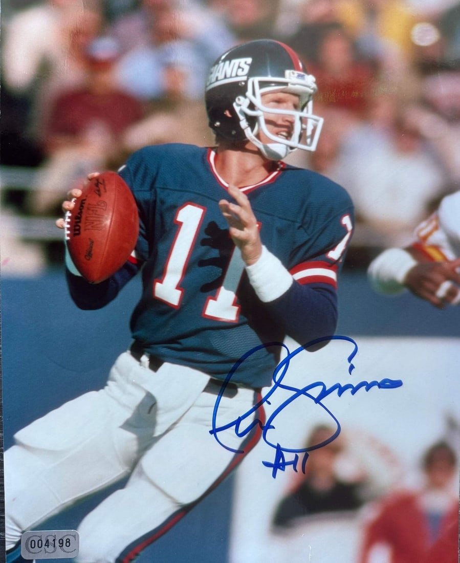 Phil Simms Autographed Giants 8x10 Football Photo: Phil Simms Autographed Giants 8x10 Football Photo Signed in blue sharpie across the front, this 8x10 football photo features an autograph from Phil Simms, a legendary quarterback with a storied career