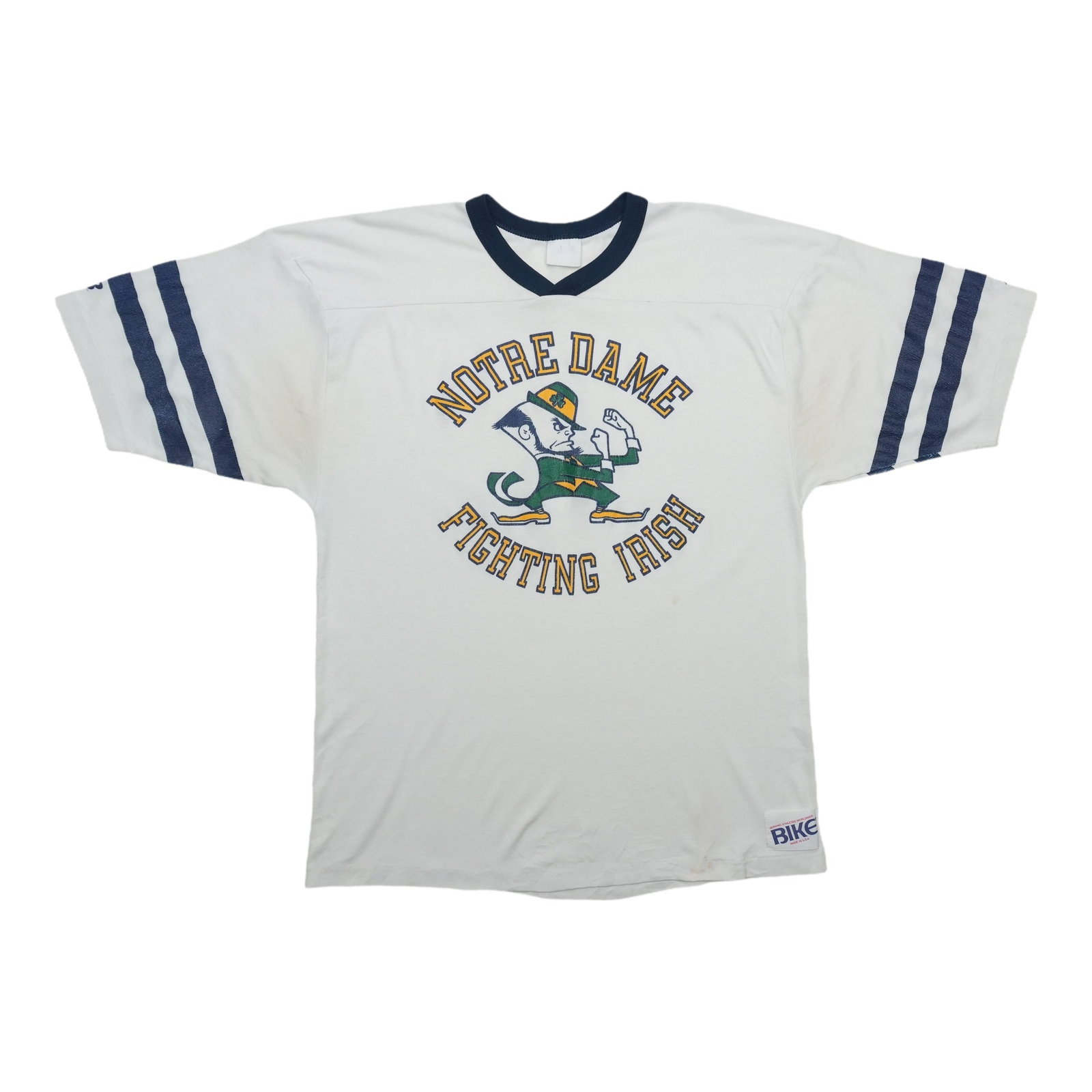 1980s Notre Dame Fighting Irish Bike Jersey: 1980s Notre Dame Fighting Irish Bike Jersey White 50/50 Cotton/Poly Bike Jersey from the 1980s Notre Dame Fighting Irish features a classic collar-to-hem design with pit to pit measurements of 19.5