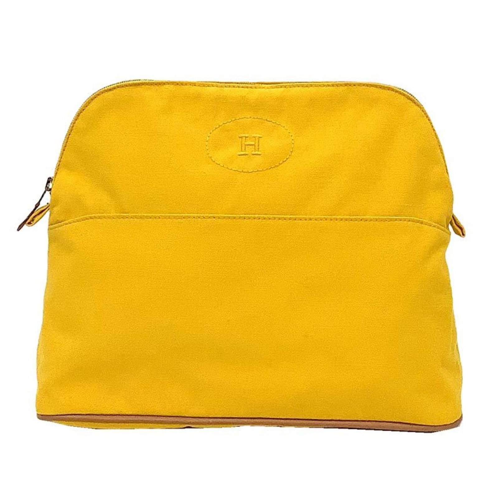 Cotton canvas pouch by Hermes: Cotton canvas pouch by Hermes Yellow cotton canvas pouch by Hermes. Made from durable cotton canvas, this 24cm x 30cm x 10.5cm pouch features a bright and cheerful yellow color. A stylish accessory