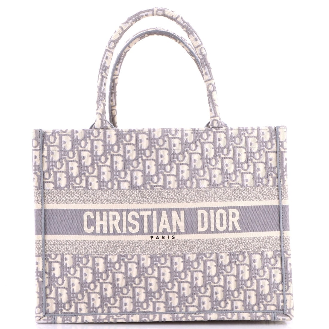 Christian Dior Book Oblique Medium Canvas Tote: Christian Dior Book Oblique Medium Canvas Tote The Book Oblique Medium Canvas Tote from Christian Dior boasts a timeless gray canvas exterior with subtle scuffs and edge wear, giving it a well-loved,