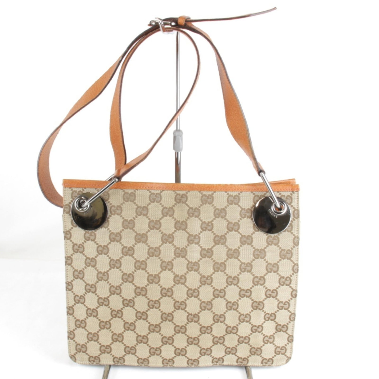 Shoulder Bag Canvas Gucci: Shoulder Bag Canvas Gucci The Gucci GG Canvas Shoulder Bag boasts vibrant orange hues and sleek design, with a sturdy magnet closure. Measuring 23cm x 27.5cm x 7cm, it features adjustable straps for a