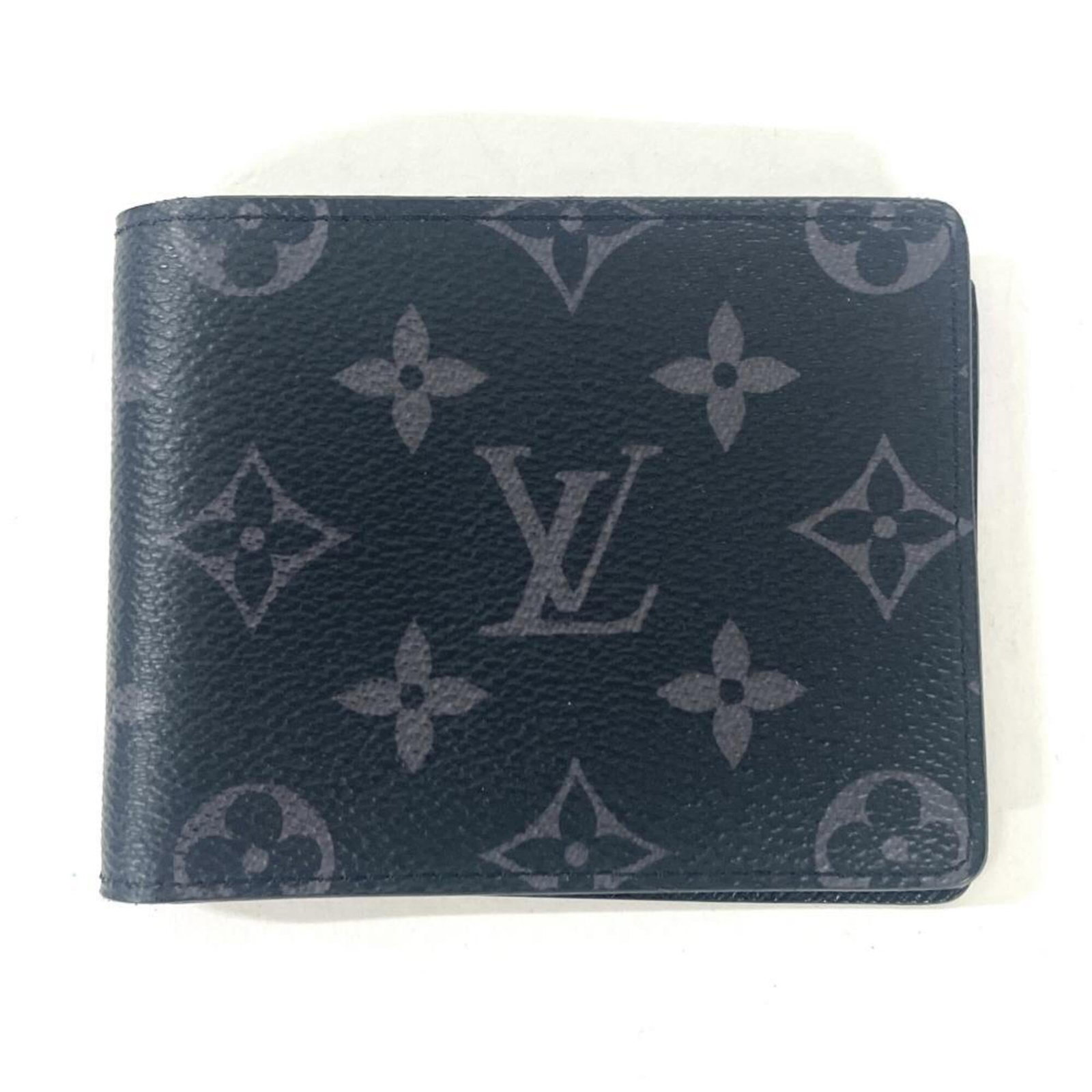 Vuitton Louis Eclipse Monogram Bi Fold Wallet: Vuitton Louis Eclipse Monogram Bi Fold Wallet The Louis Vuitton Monogram Eclipse Bi Fold Wallet is a sleek and sophisticated accessory, featuring the iconic Monogram Eclipse pattern in black. With