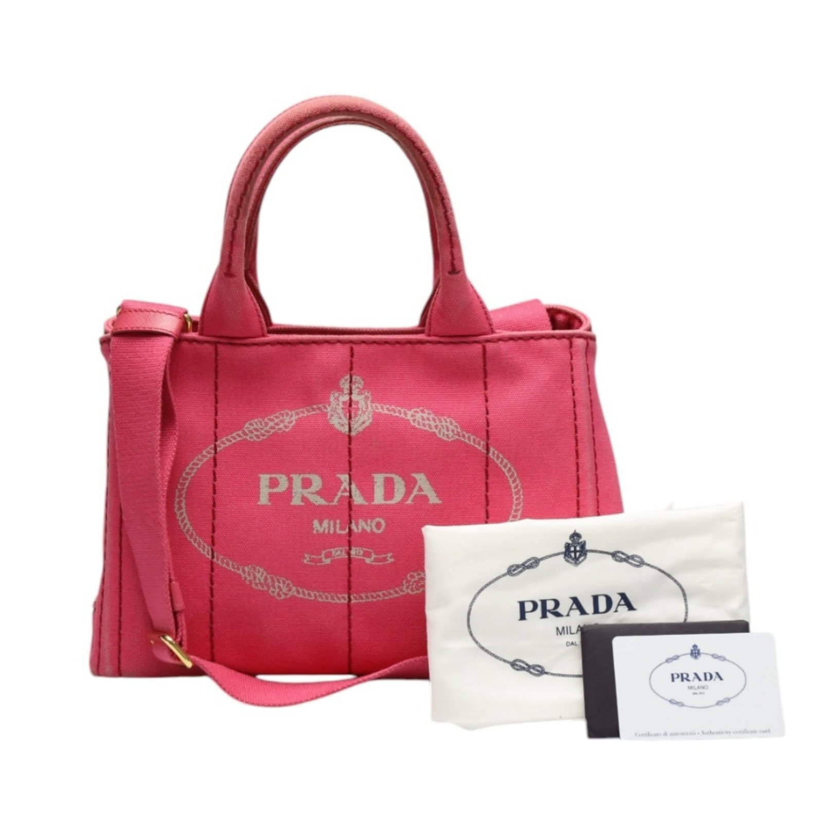 Tote bag canvas by Prada: Tote bag canvas by Prada Prada's canvas tote bag boasts a vibrant pink hue, adding a pop of color to any outfit. This stylish accessory comes with a dust bag and adjustable shoulder strap for added