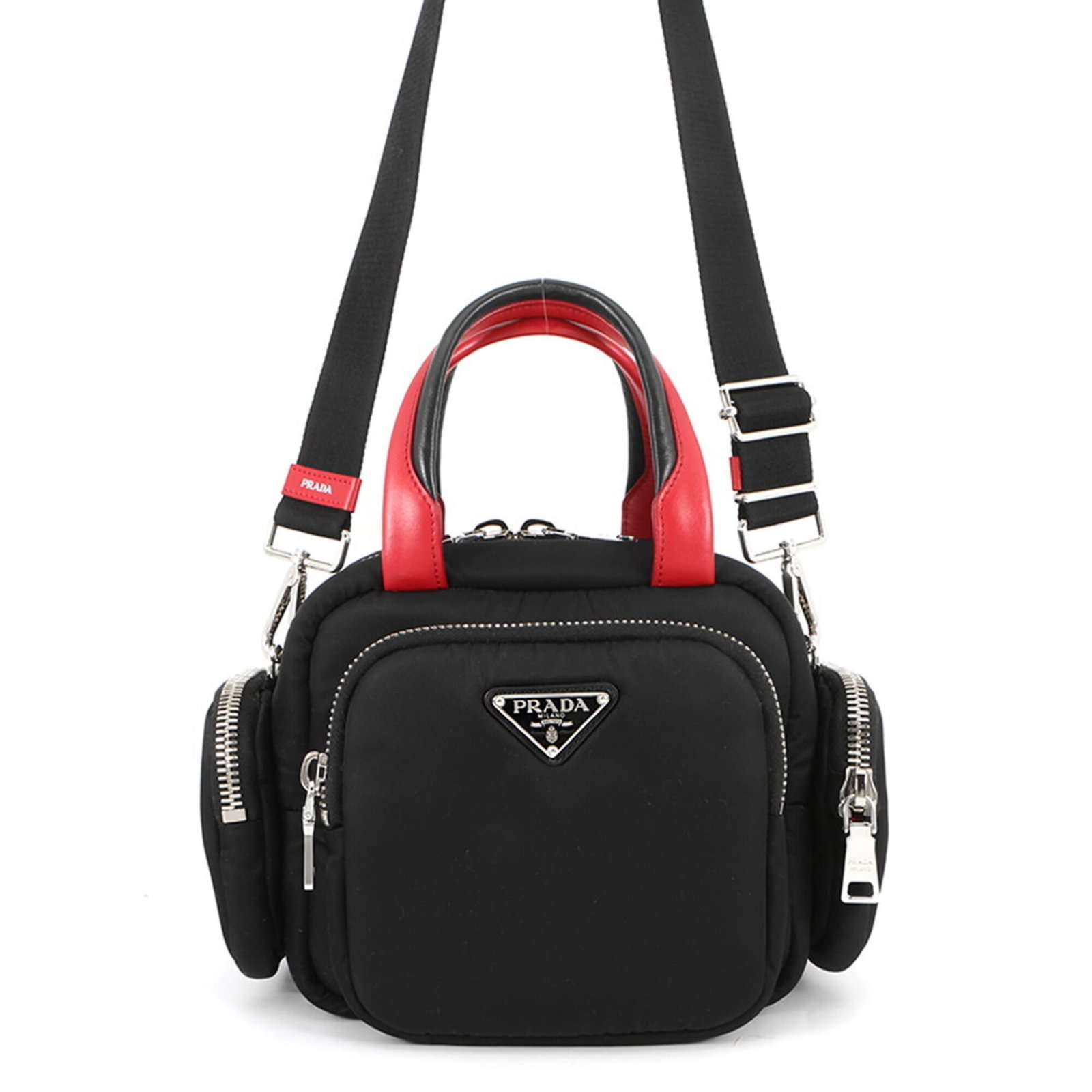 Nylon leather shoulder handbag by Prada: Nylon leather shoulder handbag by Prada Nylon leather shoulder handbag by Prada features a sleek black design with a pop of red color. The bag boasts a silver zipper closure, a functional outer