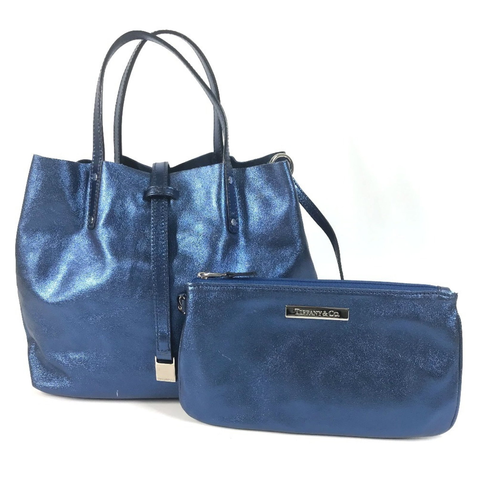 Handbag Leather Pouch Tote Tiffany: Handbag Leather Pouch Tote Tiffany Tiffany Country of Origin Italy. This blue, metallic leather tote bag features a classic design with a 23cm x 22cm x 13cm size, making it the perfect accessory for