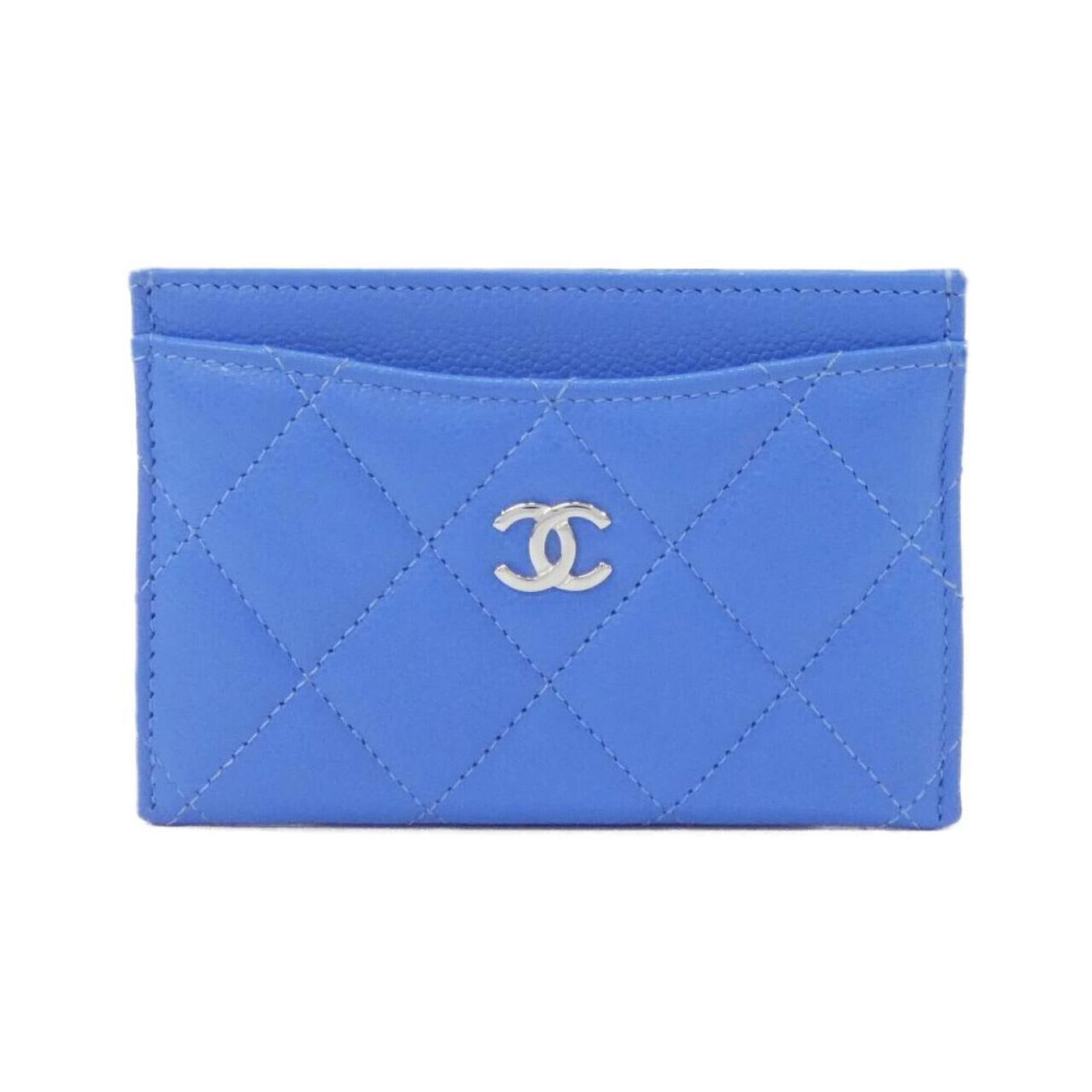 Calfskin card case by Chanel: Calfskin card case by Chanel Light blue calfskin card case by Chanel, measuring 7.5cm x 11cm x 1cm in size, features a grained material and classic design. This elegant accessory showcases the iconic