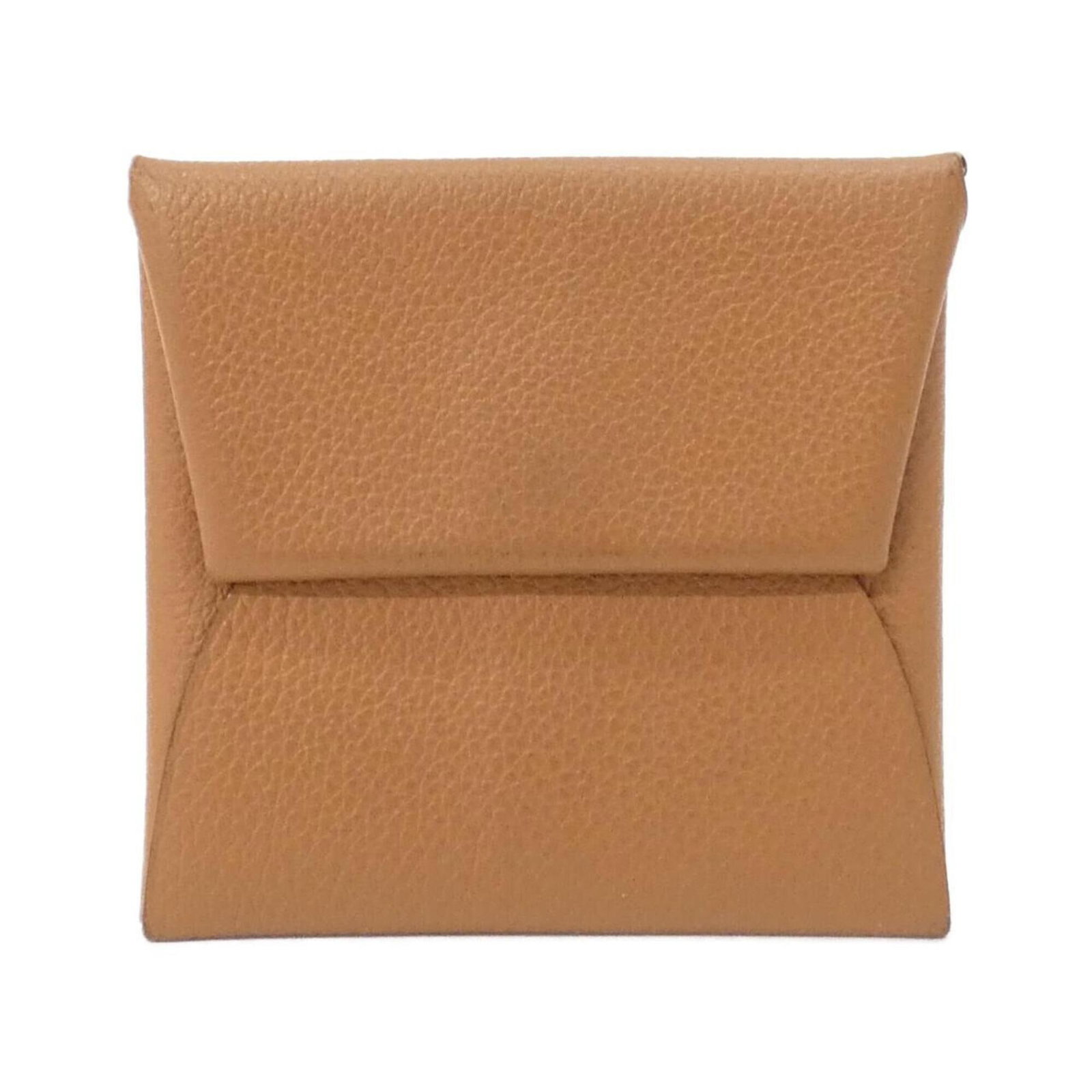 Coin purse by Hermes: Coin purse by Hermes This elegant coin purse by Hermes features a classic beige and gold design, measuring 8cm x 9cm x 1cm. The simple yet sophisticated shape makes it a versatile accessory for