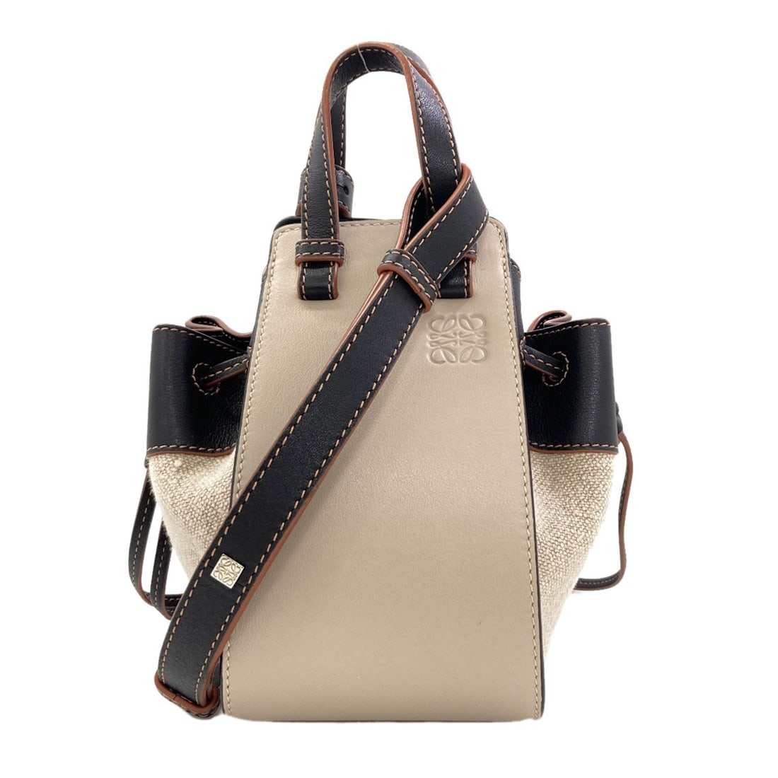 Loewe Hammock Mini 2Way Handbag Calf: Loewe Hammock Mini 2Way Handbag Calf Beige calf leather wraps around the body of this Loewe Hammock Mini 2Way Handbag, creating a sleek and sophisticated silhouette. The exterior material is made