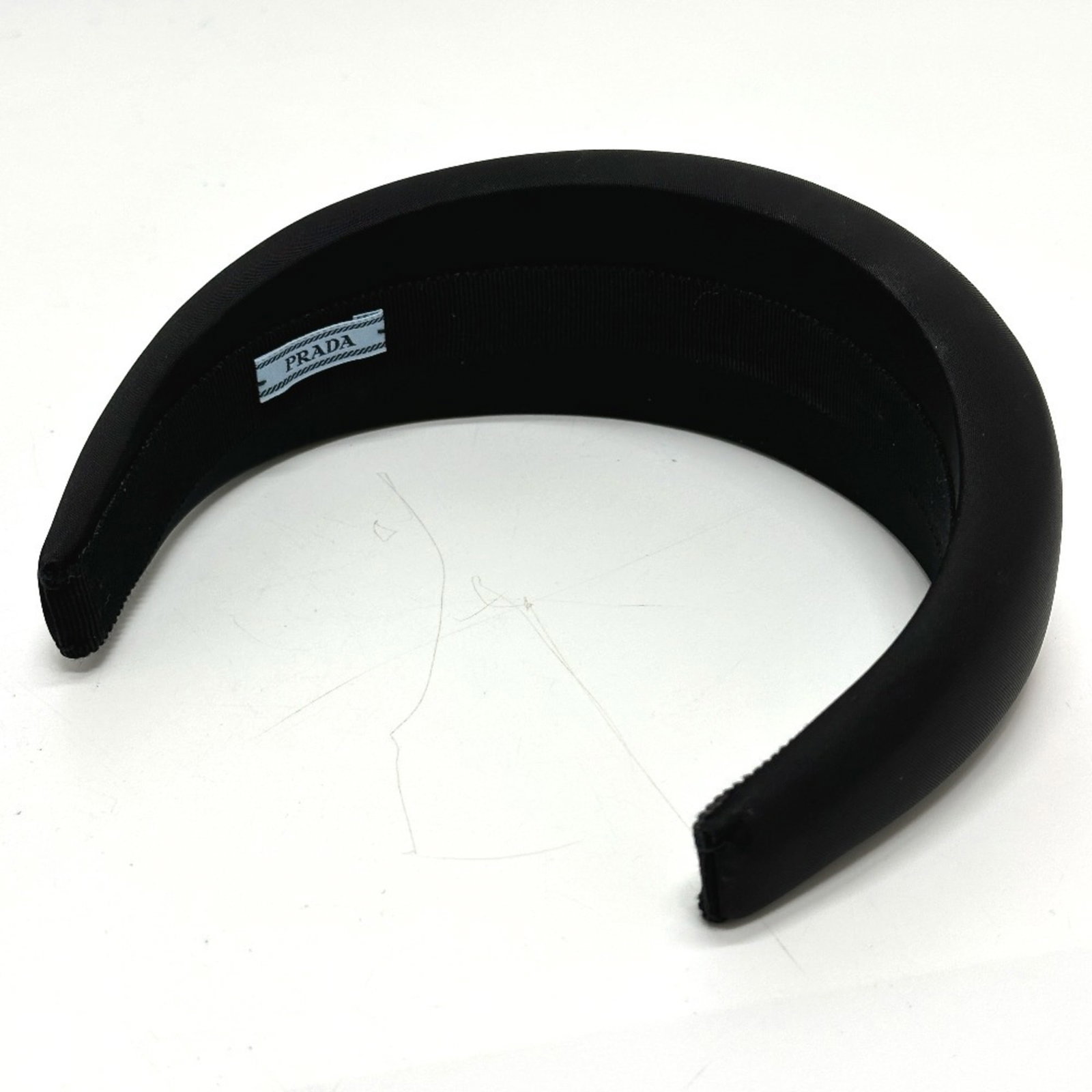 Headband Nylon by Prada: Headband Nylon by Prada Black Prada Headband made from Nylon, measuring 42.5cm x 16.73'' and accompanied by a box and dust bag. This headband bears the signature of its brand, Prada. The item is prese