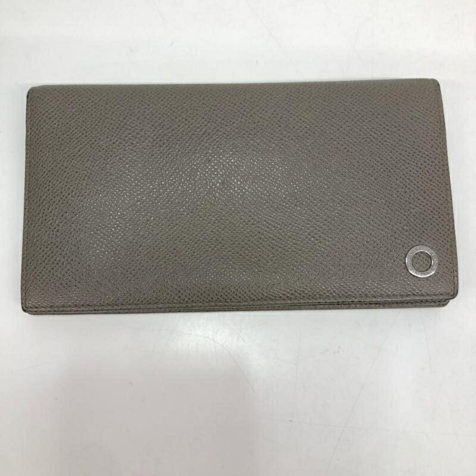 Long Bi Fold Wallet by Bvlgari: Long Bi Fold Wallet by Bvlgari Bvlgari's Long Bi Fold Wallet boasts sleek, modern design with a gray color and precise measurements at 10cm x 17.5cm / 3.93'' x 6.88''. This bi-fold wallet is crafted t